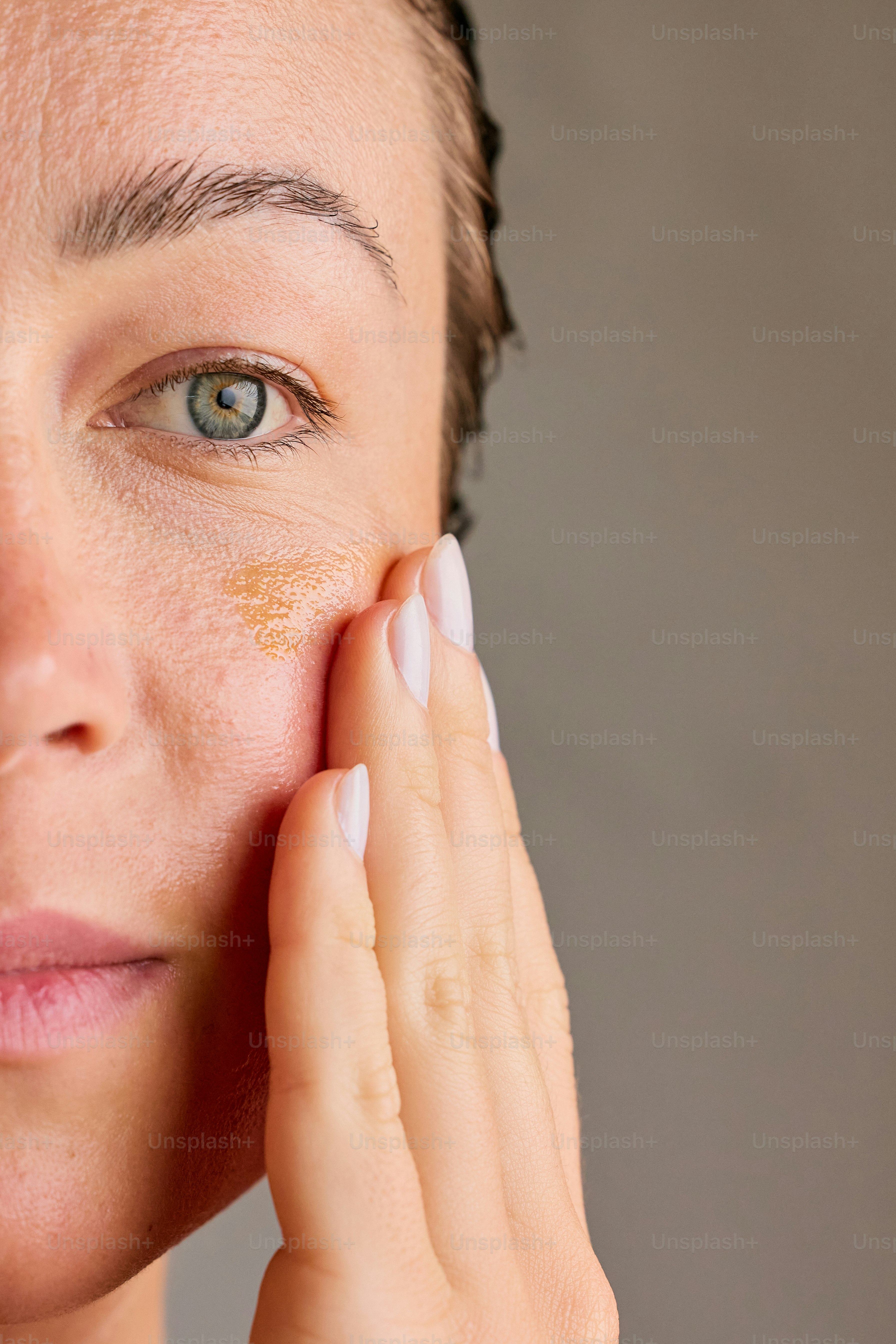 Woman applying serum to her face with fingers