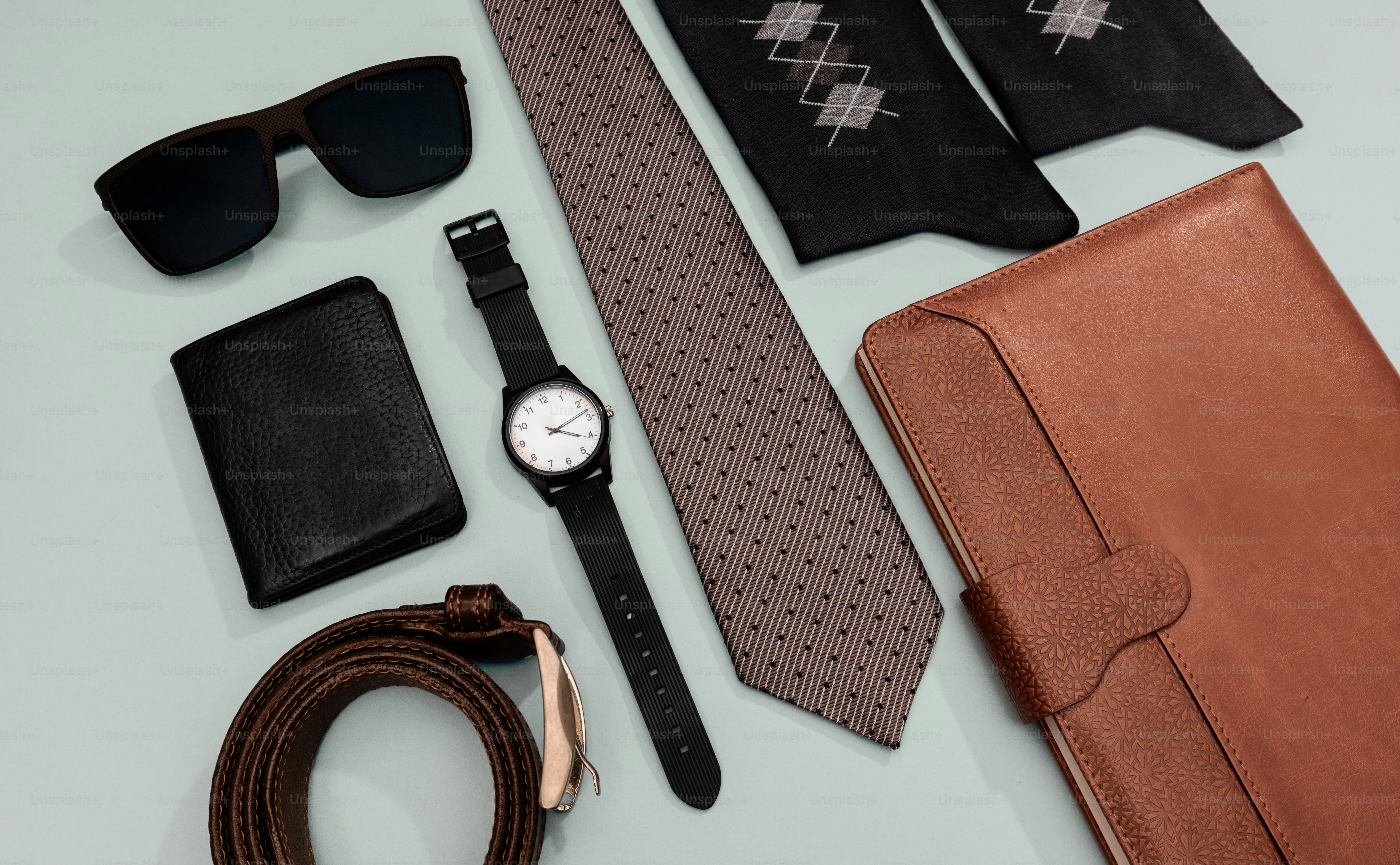 Men's accessories including sunglasses, wallet, watch, tie, and notebook.
