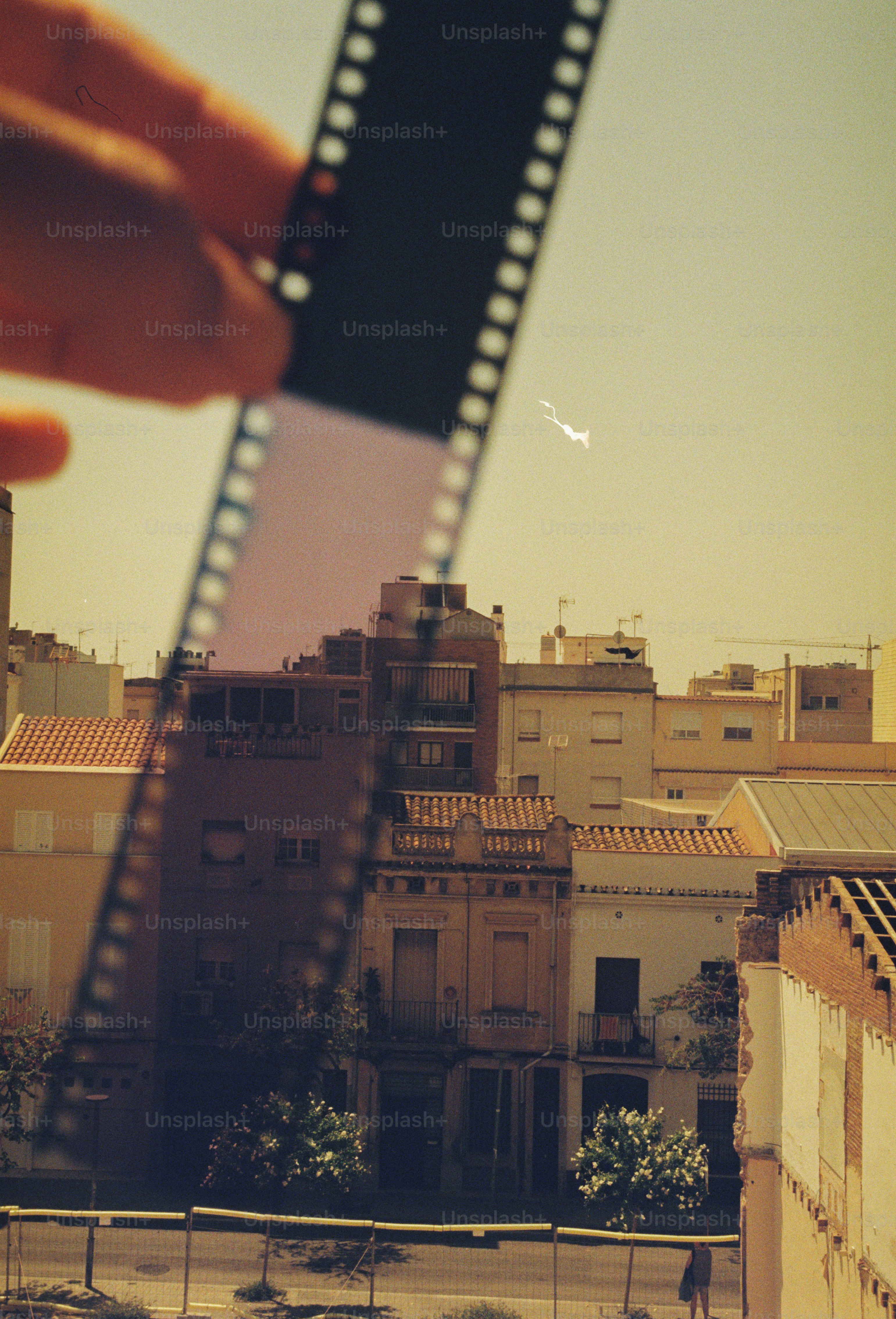 Tira de filme de mão segurando com fundo de paisagem urbana