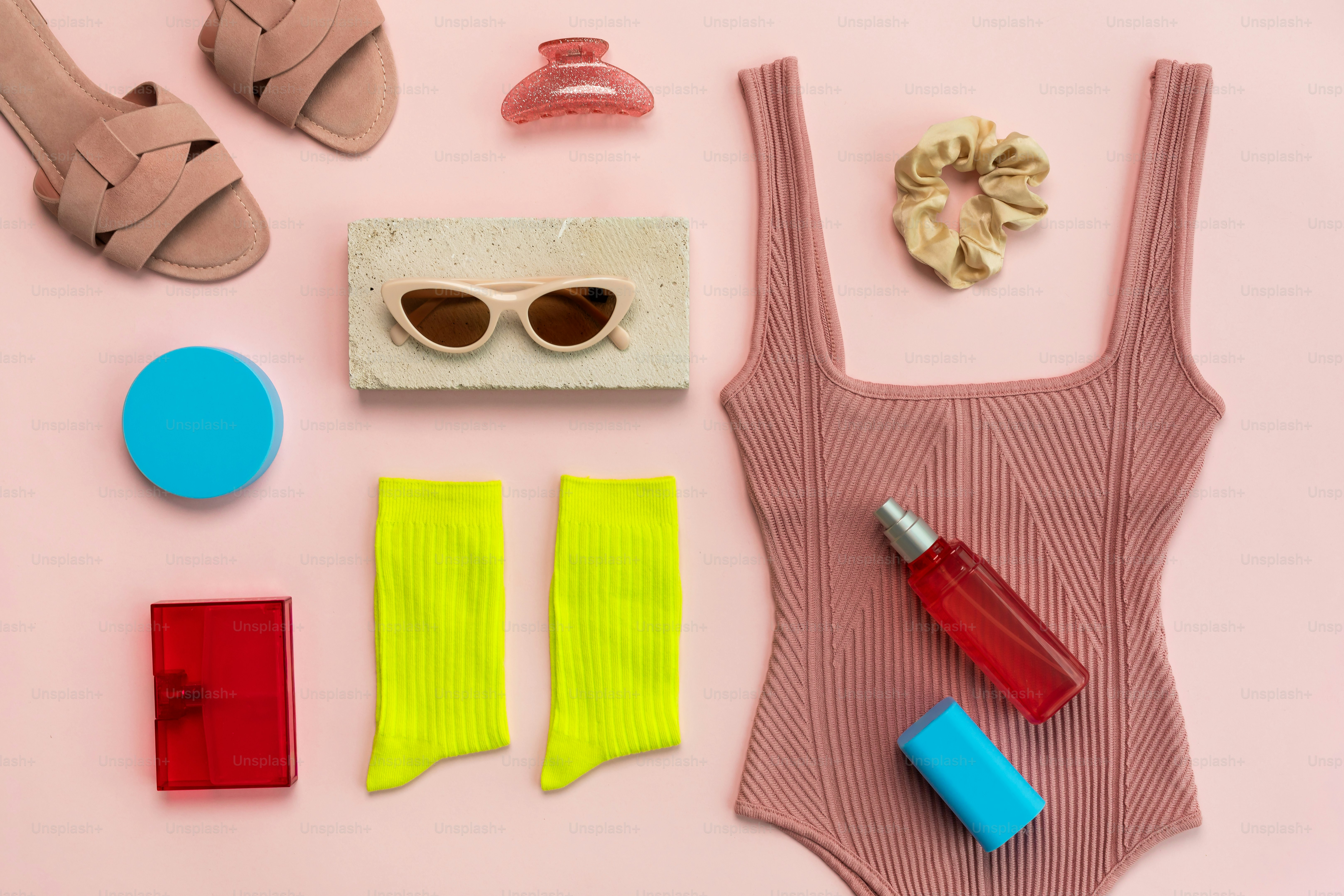 Pose à plat d’articles de mode et de beauté d’été sur rose