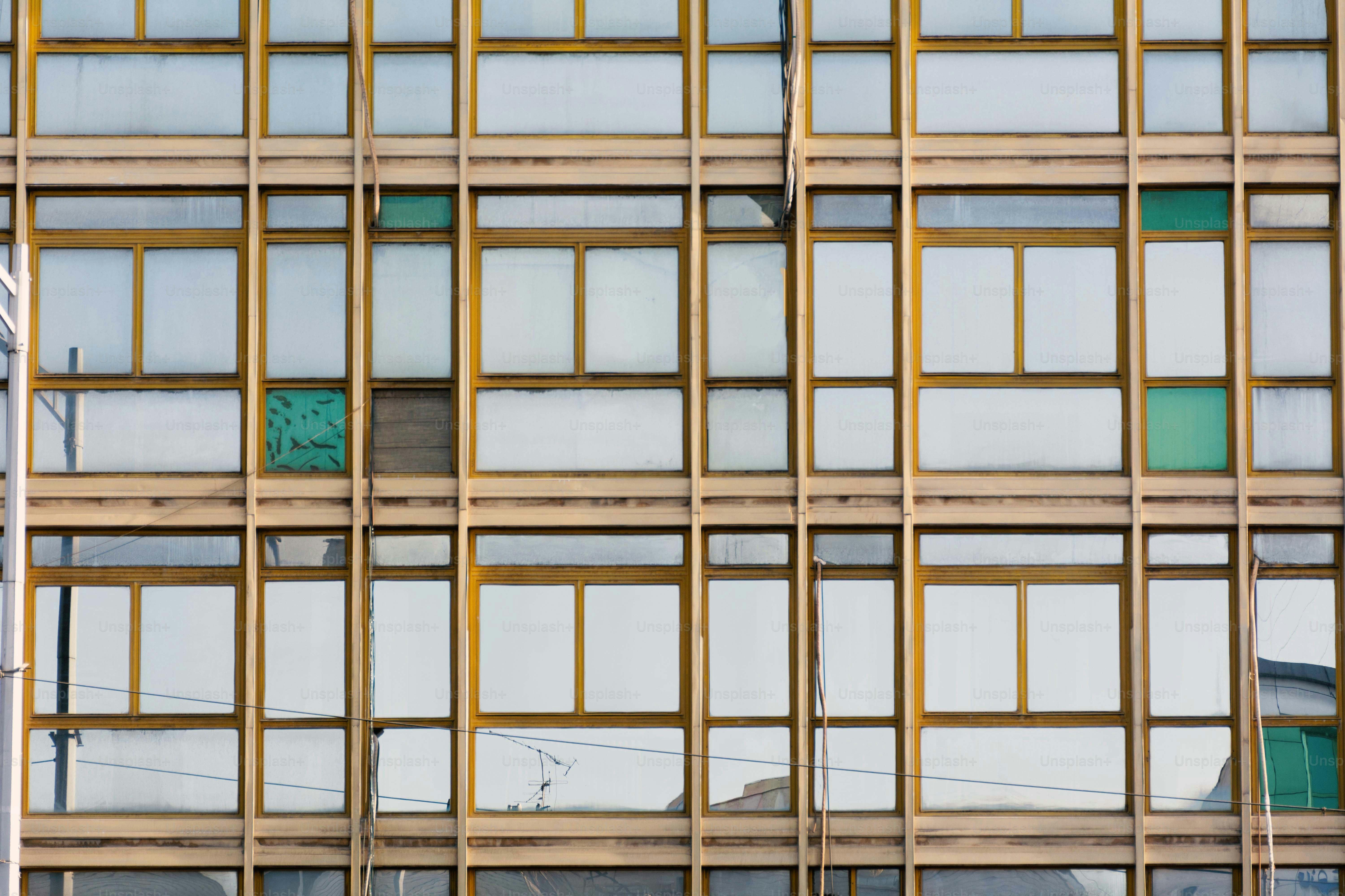 Fachada moderna del edificio con ventanas repetidas y paneles desgastados