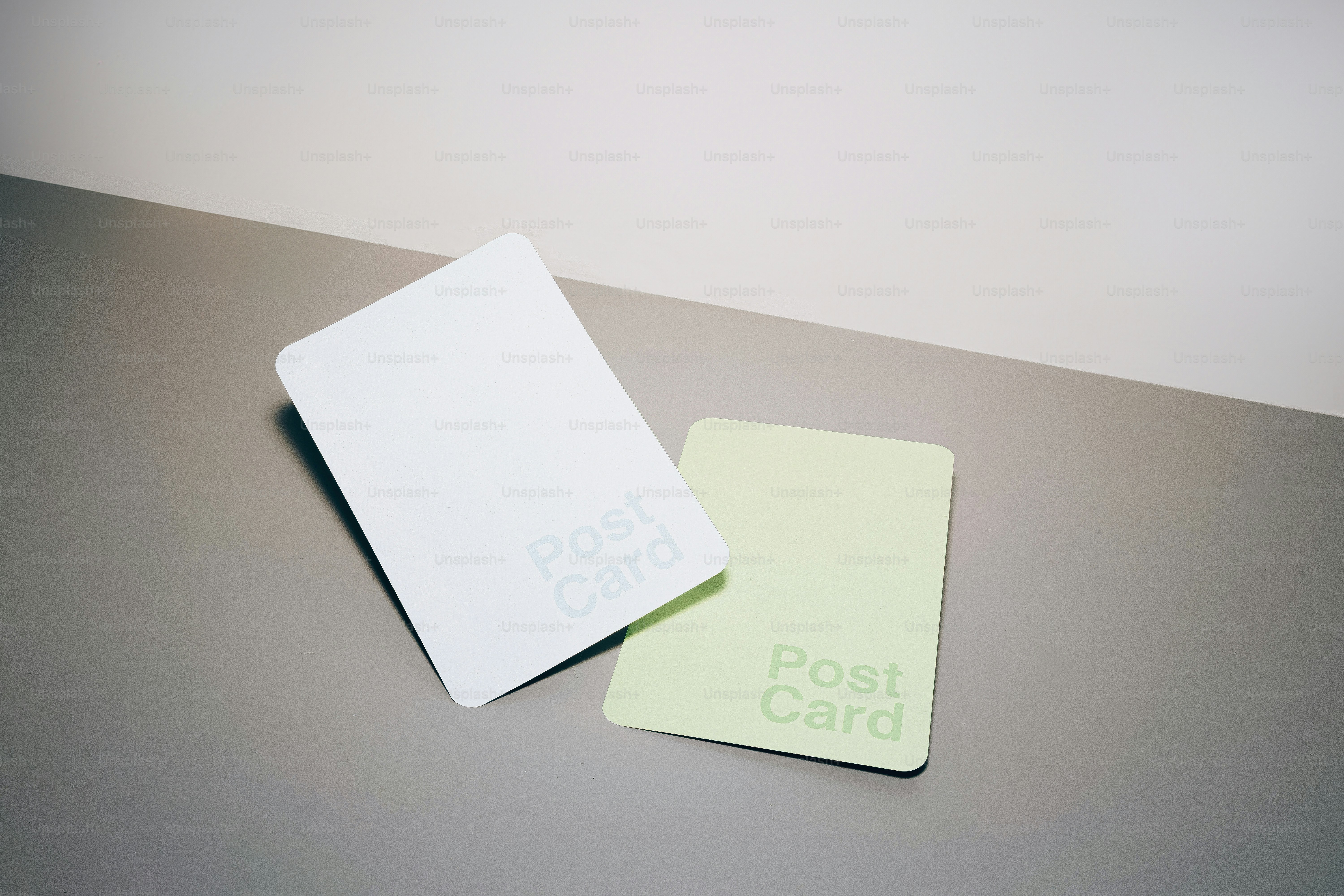 Two blank postcards on a grey surface.