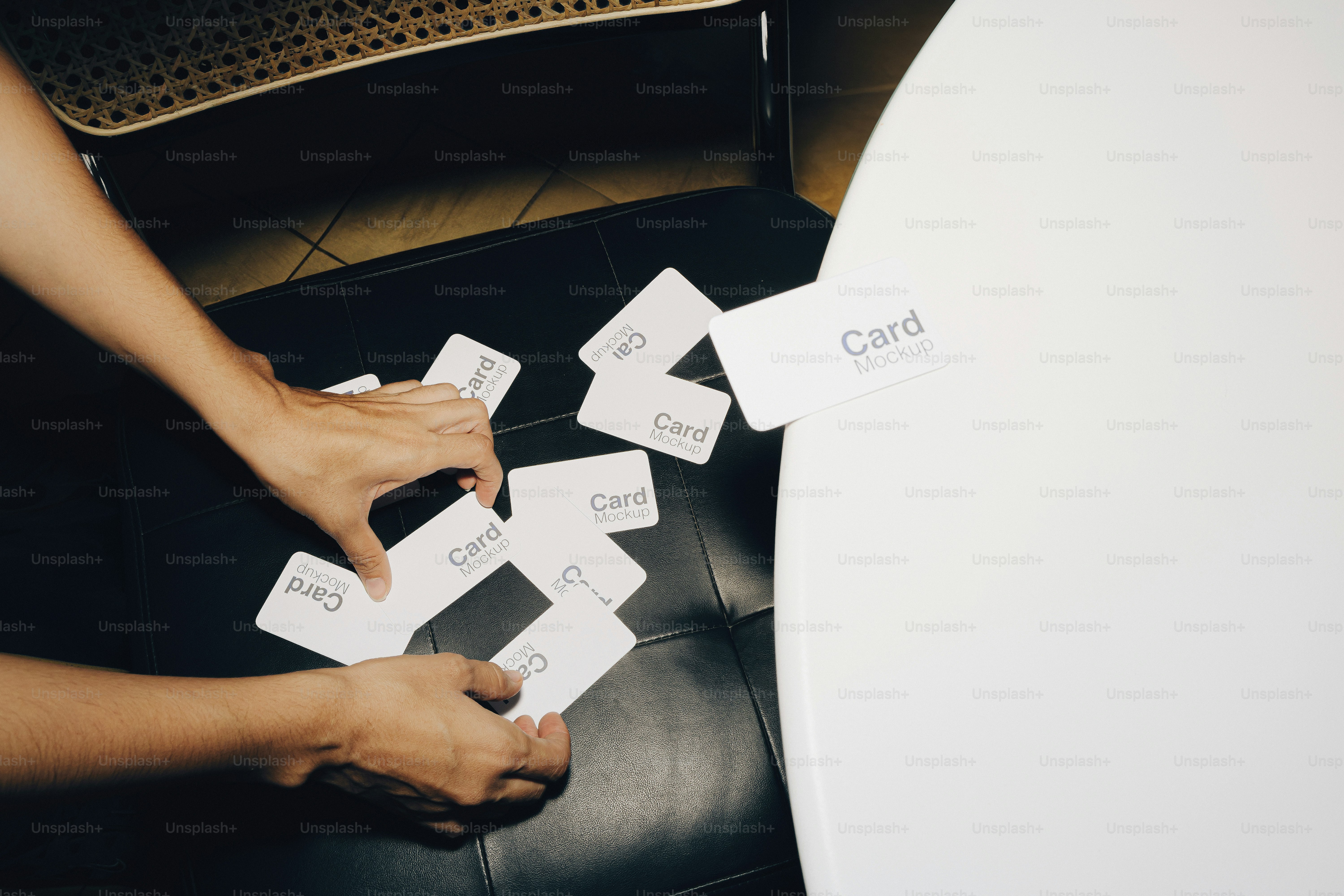 Mani che dispongono le carte bianche su una superficie scura.