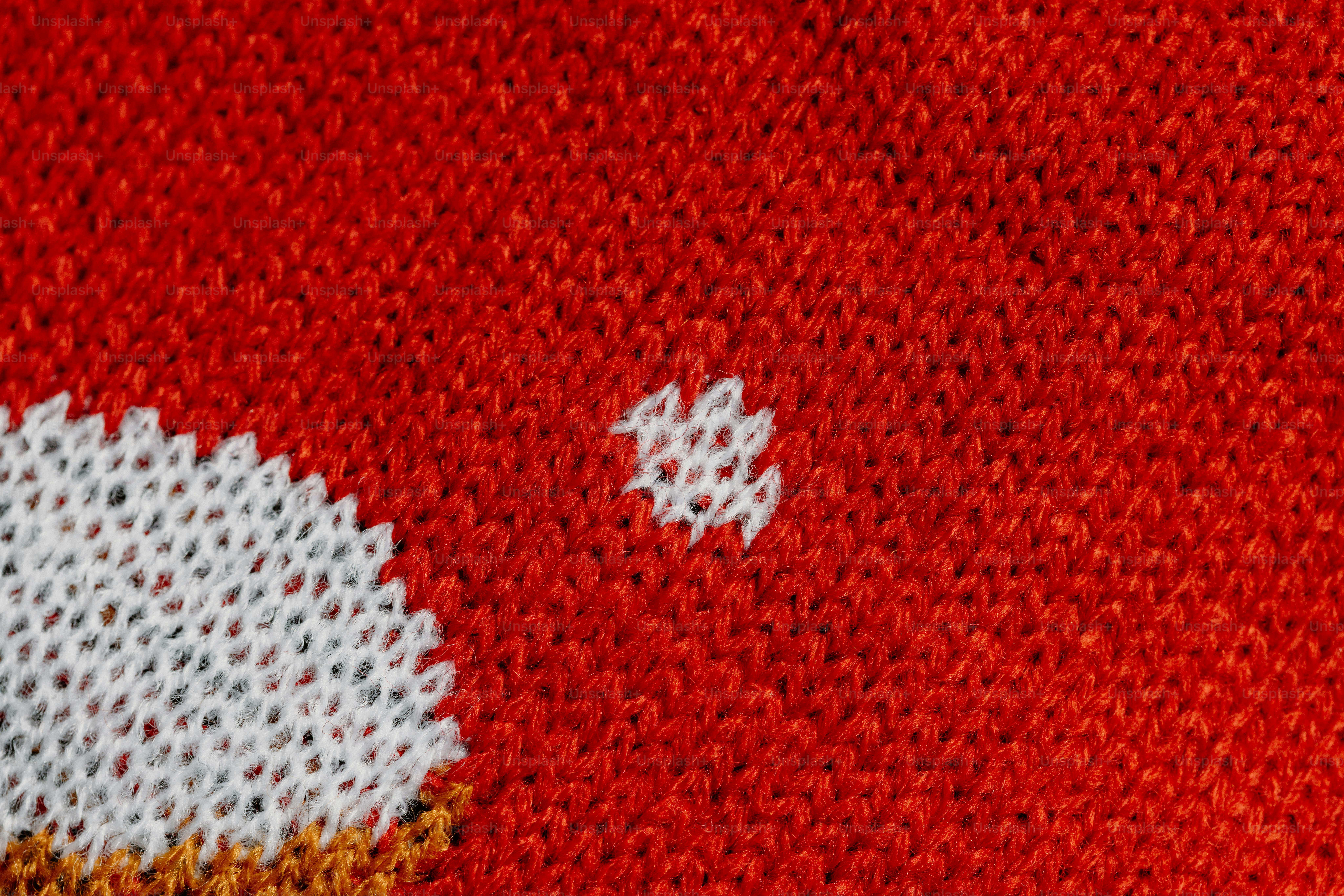 Red knitted fabric with a small white pattern.