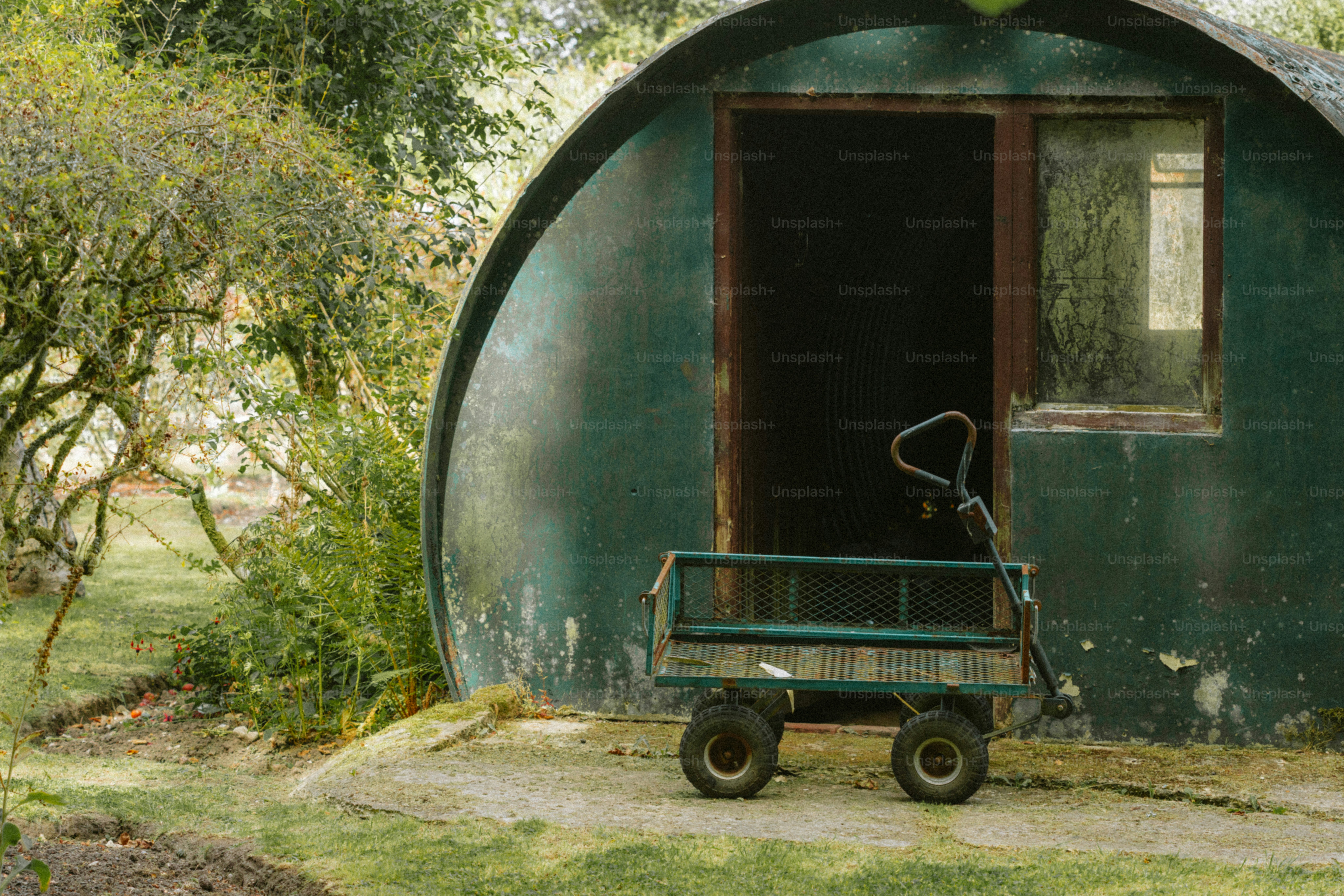 Vagão verde estacionado do lado de fora de um prédio verde redondo.