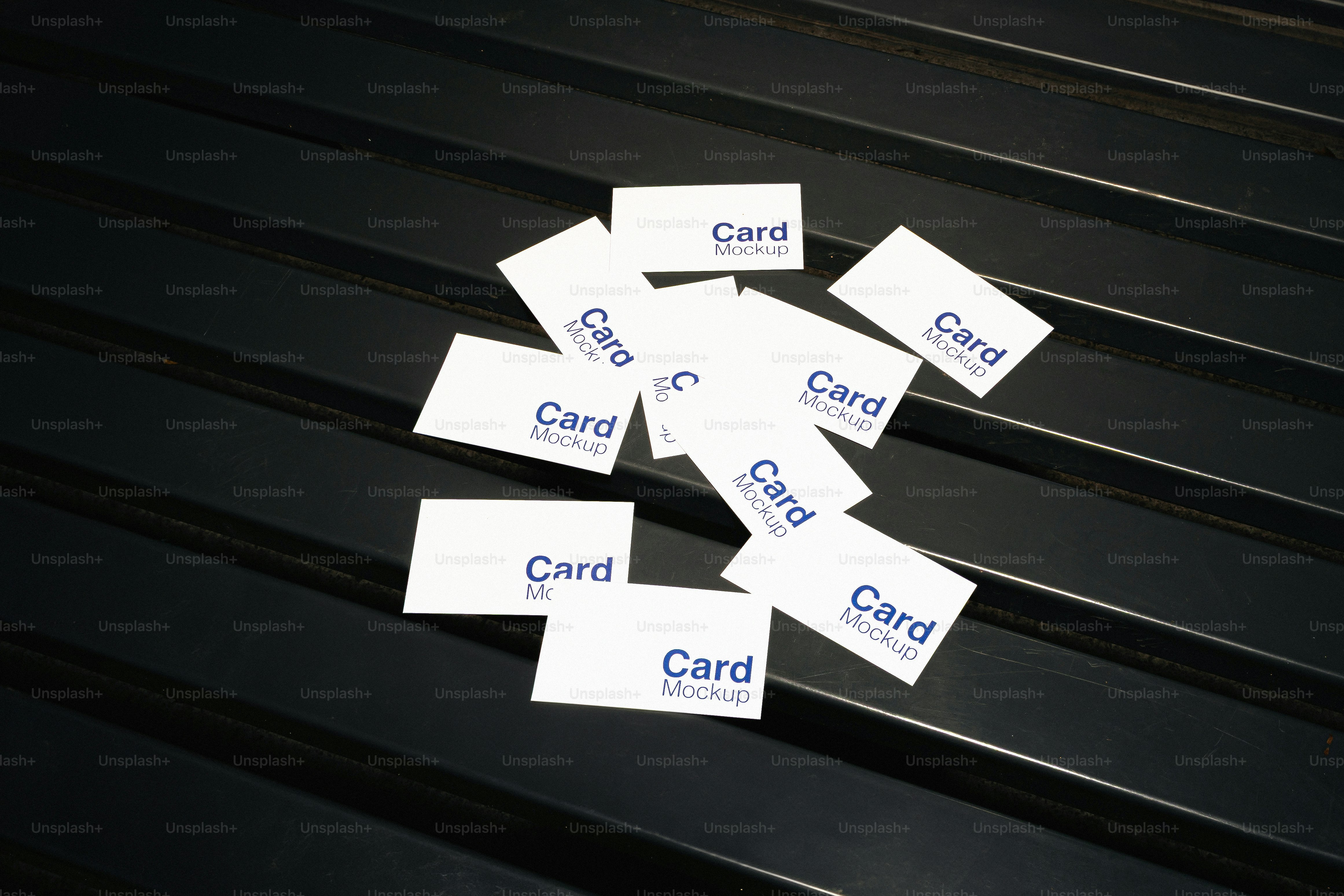 Several white cards with blue text scattered on black surface