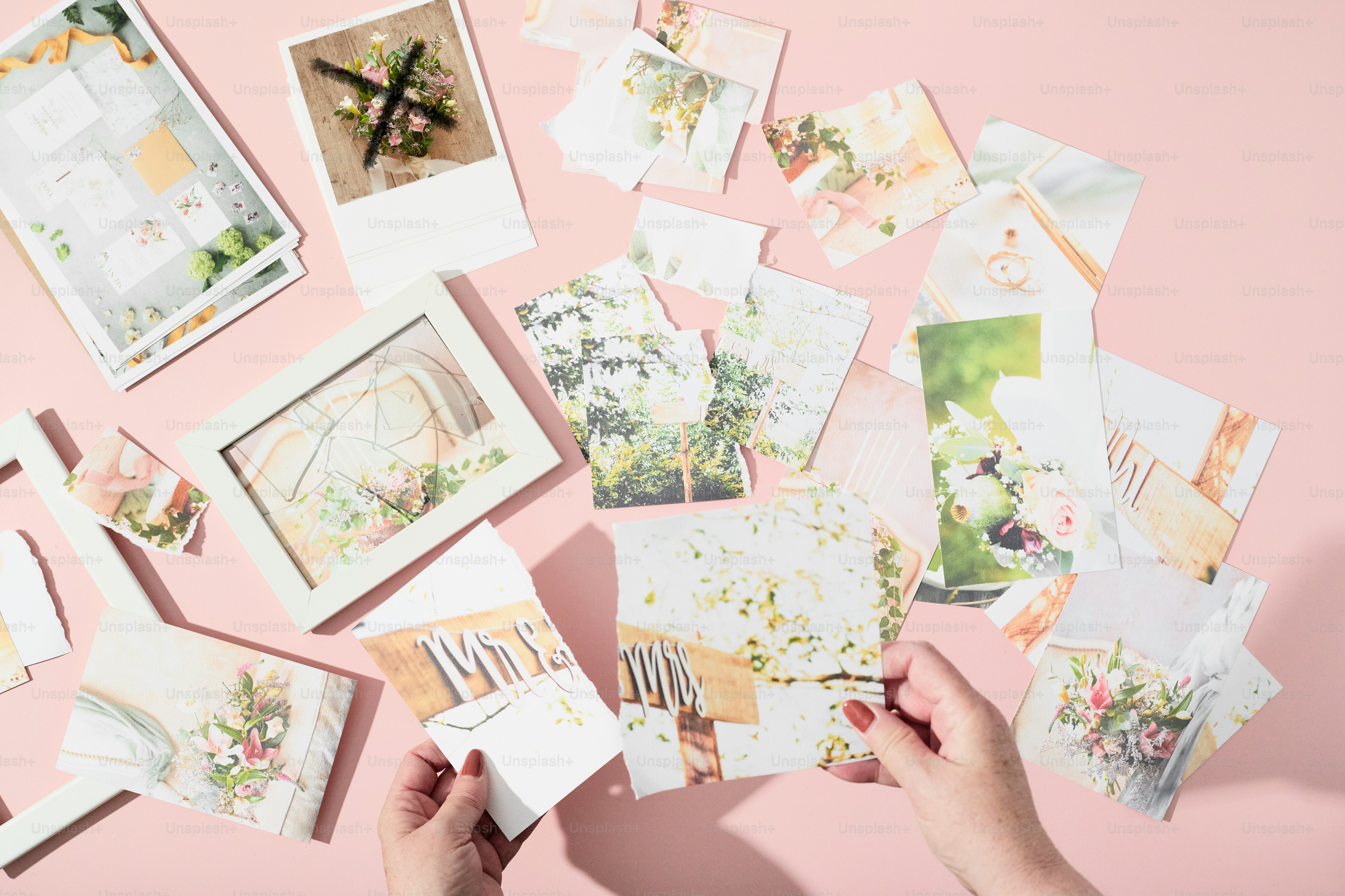 Hände arrangieren florales Briefpapier und gerahmte Kunstwerke