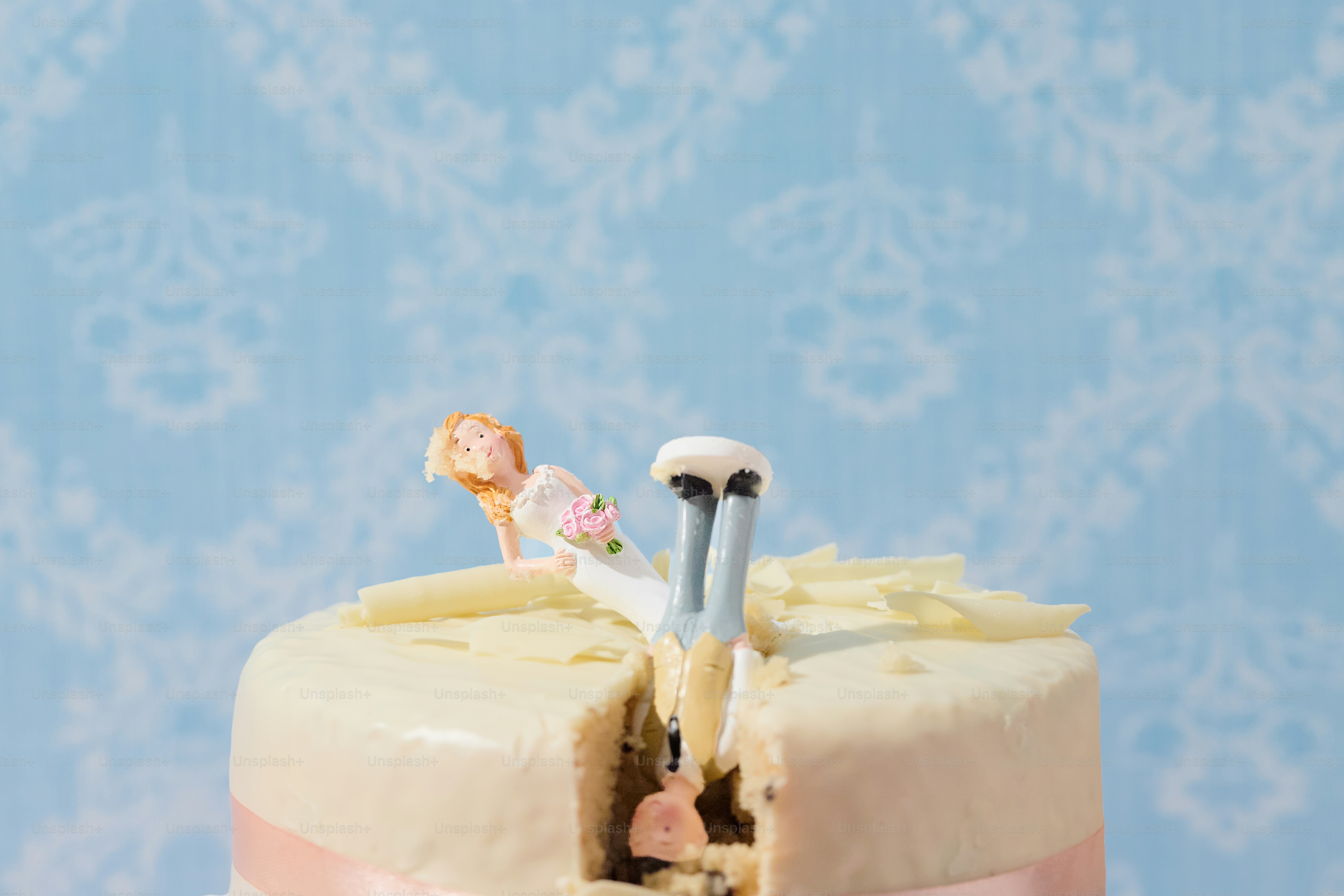 Braut und Bräutigam figuren auf einer angeschnittenen Hochzeitstorte.