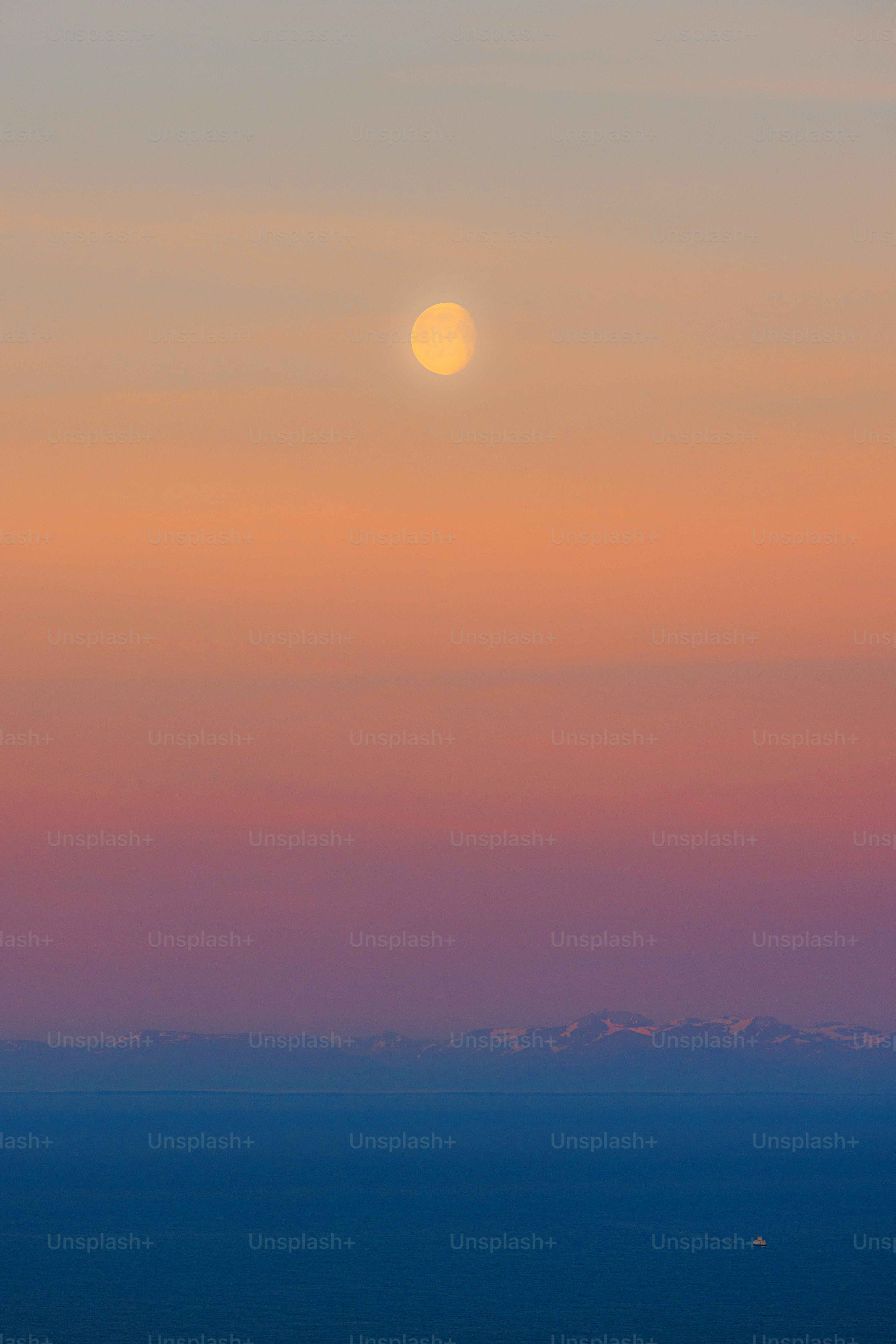 Full moon over the ocean at sunset