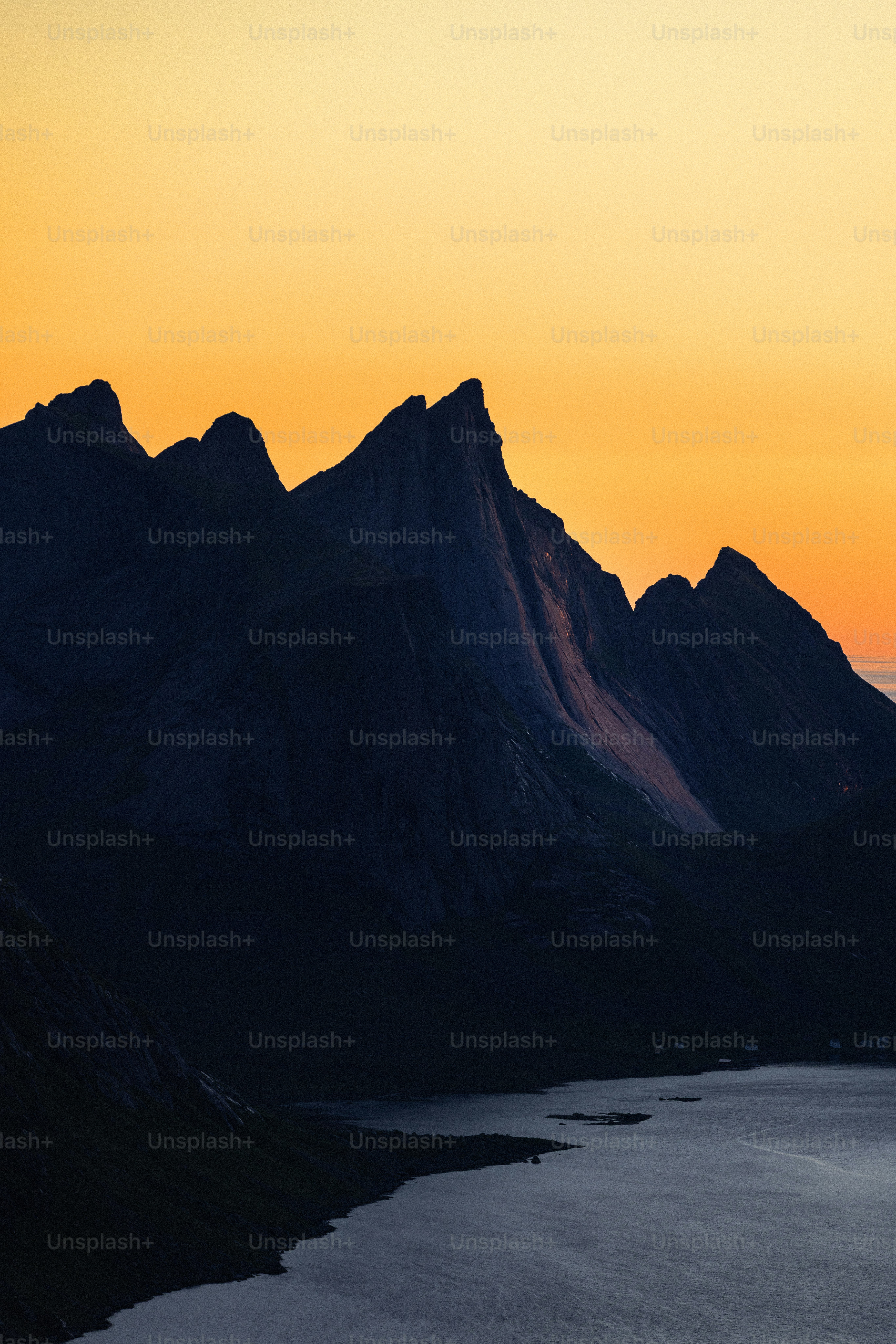 Jagged mountain peaks silhouetted against a vibrant sunset sky.