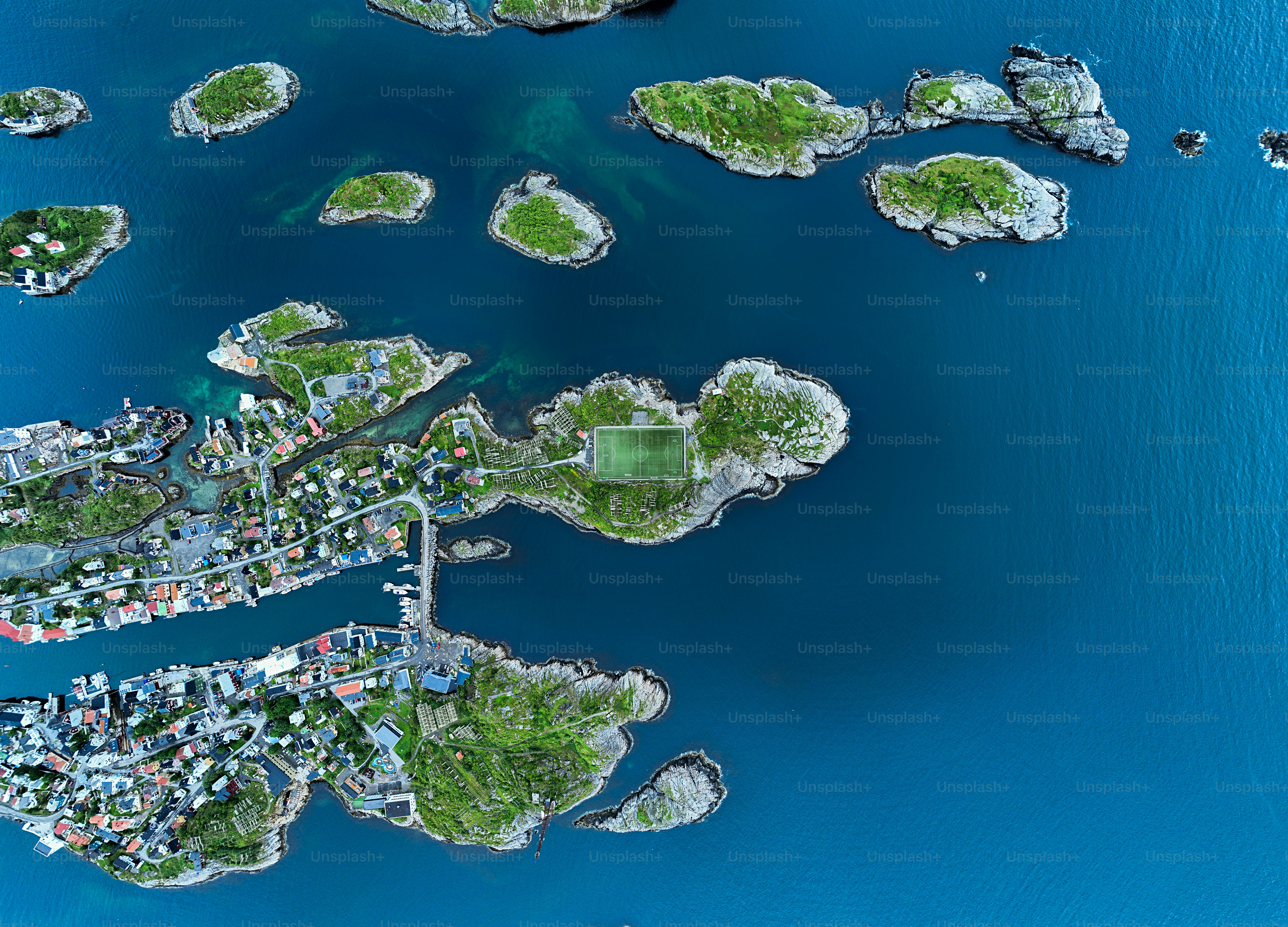 Luftaufnahme von Inseln mit Häusern und einem Fußballplatz.