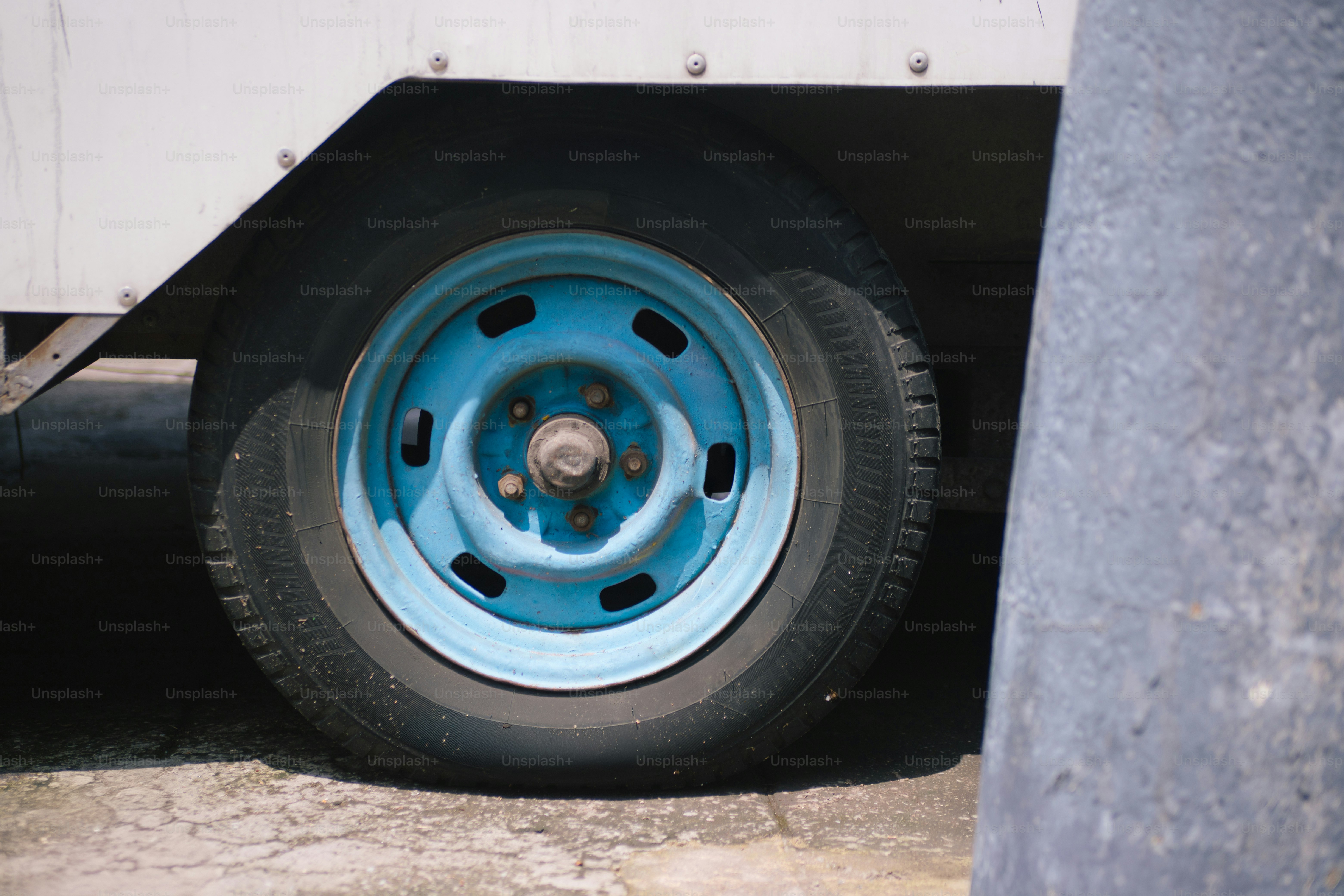Close up of a flat tire with a blue rim.
