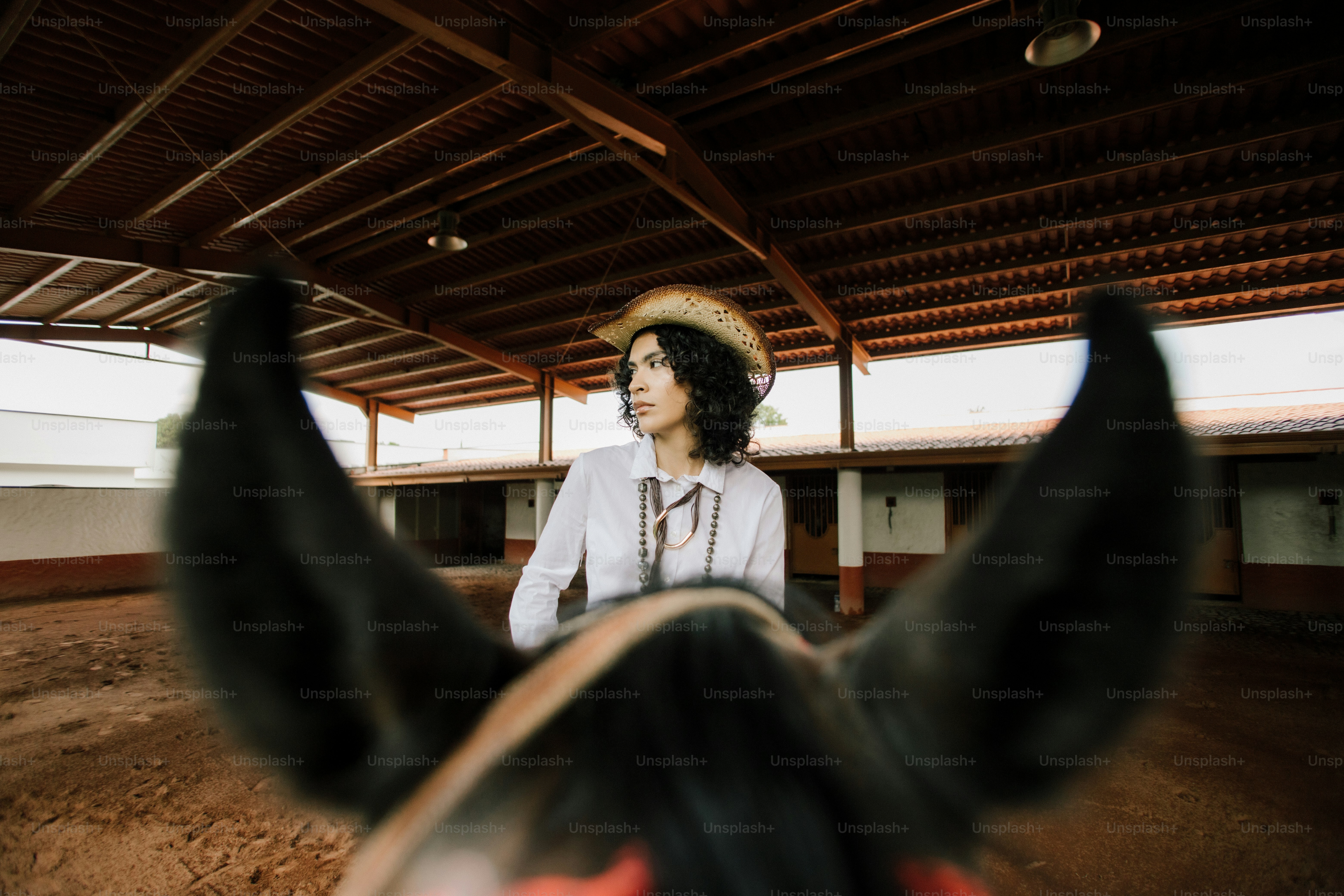 Woman riding a horse in an indoor arena.
