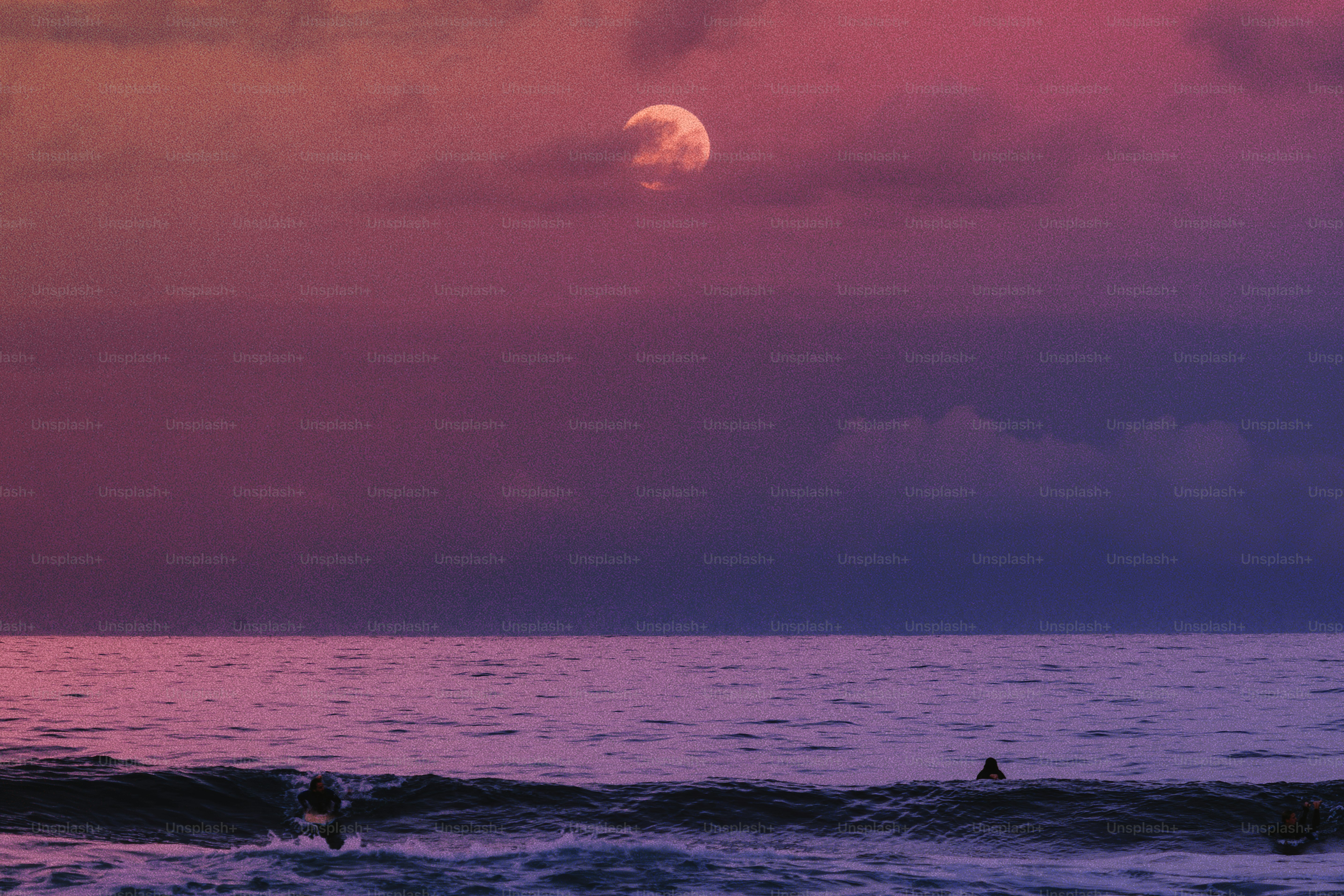 La luna piena sorge sulle onde dell'oceano al tramonto