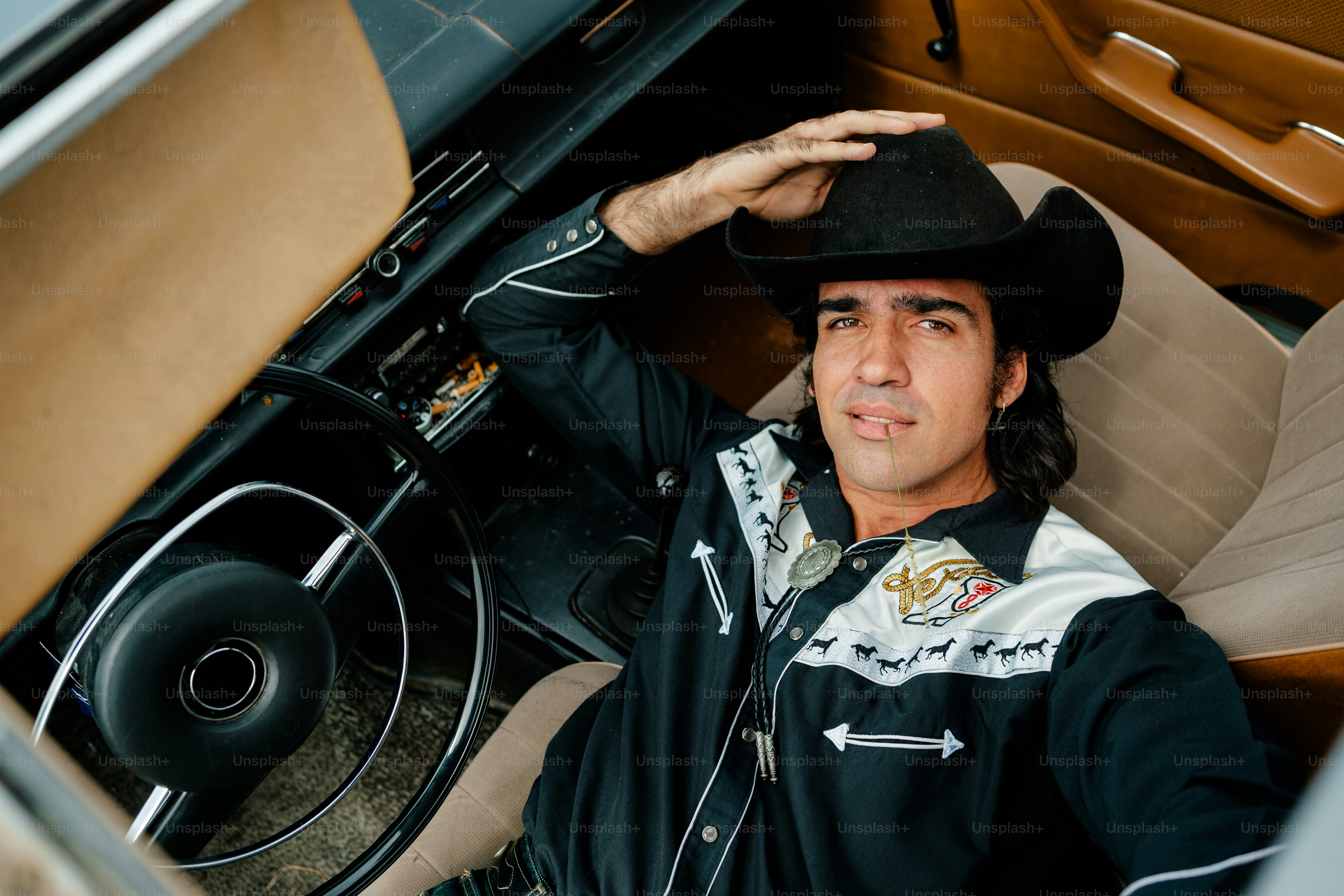 Man in cowboy hat and shirt inside car
