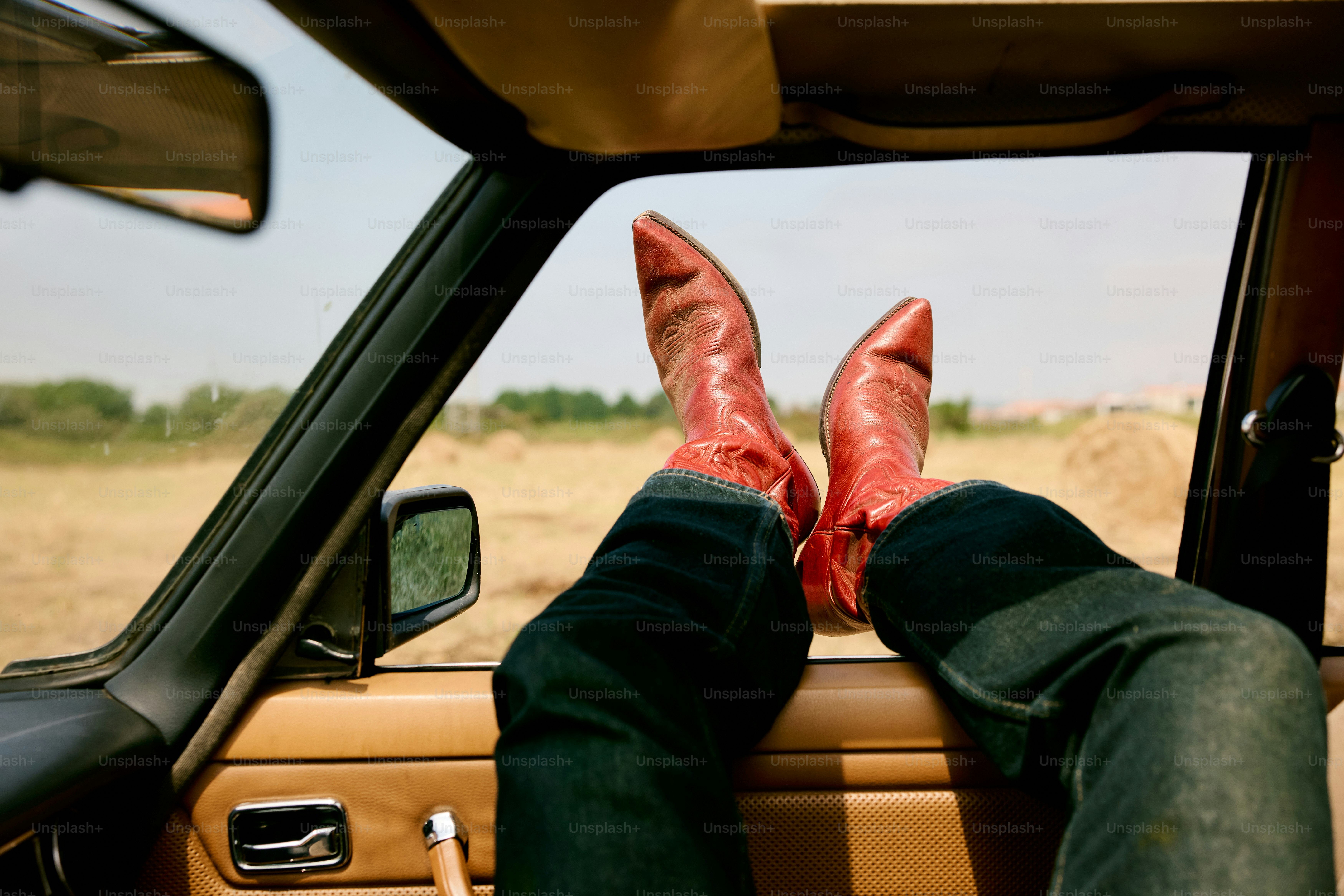 Person wearing red cowboy boots in car