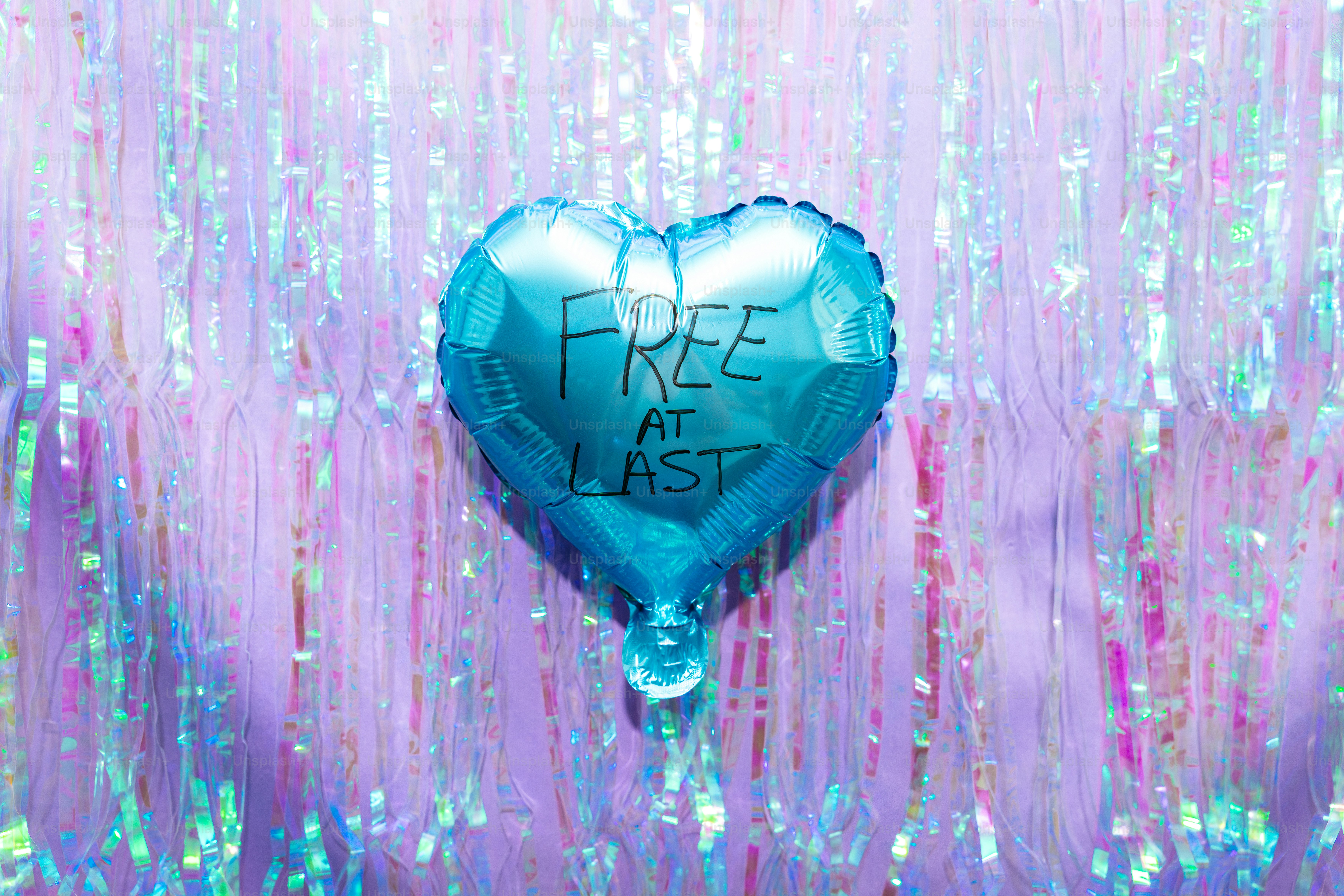 Blue heart balloon with "free at last" text.