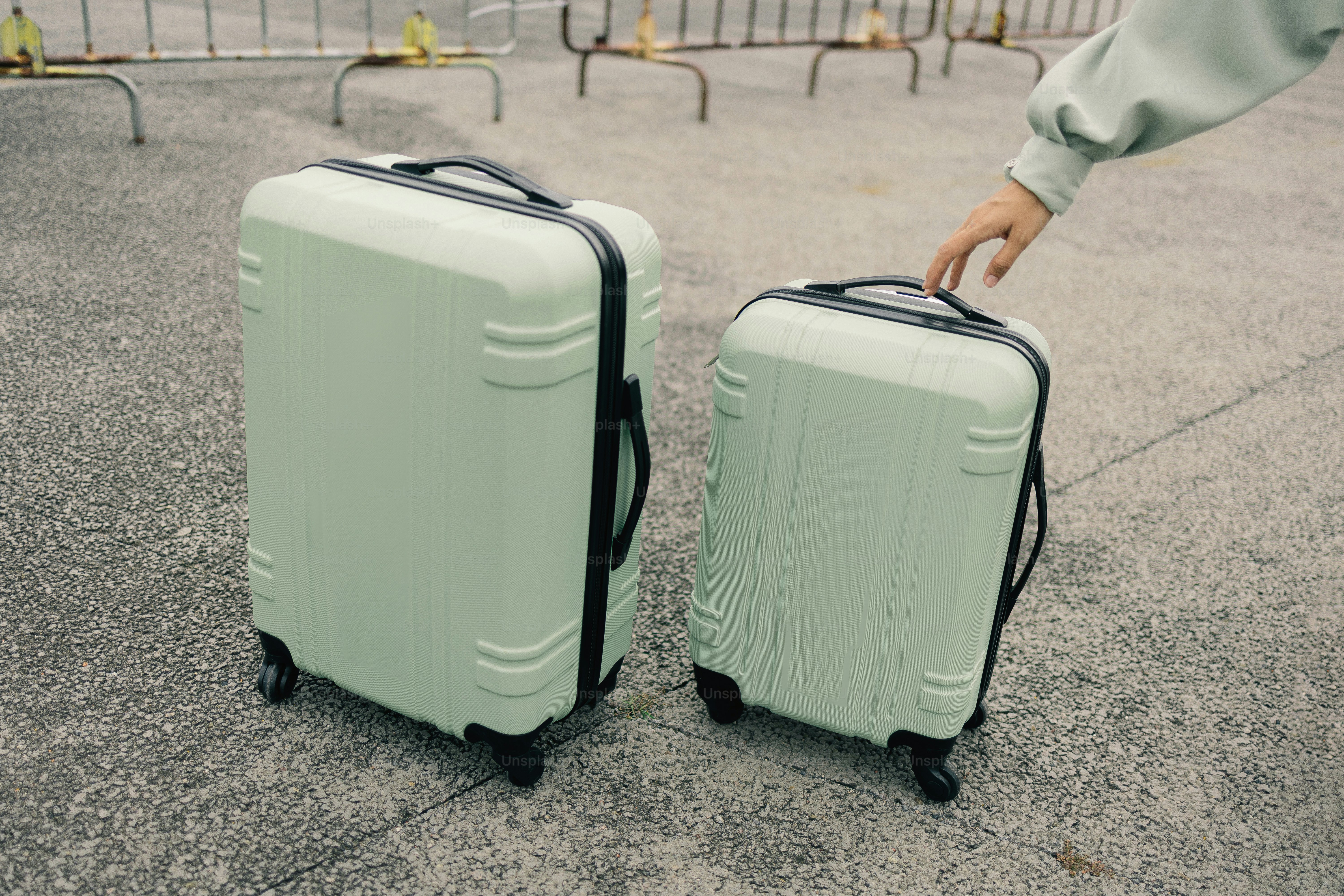 Two mint green suitcases on pavement