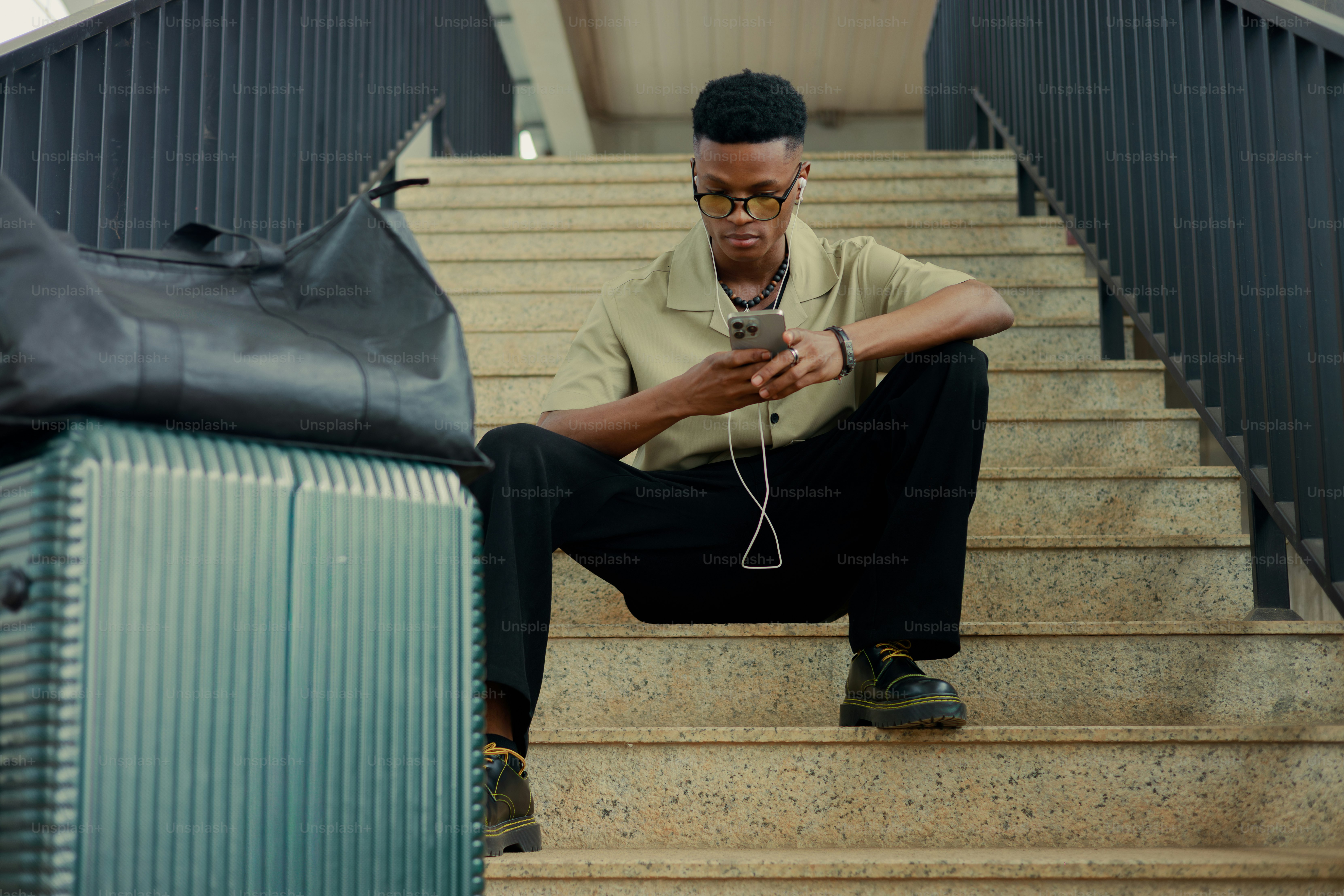 Man sitting on stairs with luggage and phone
