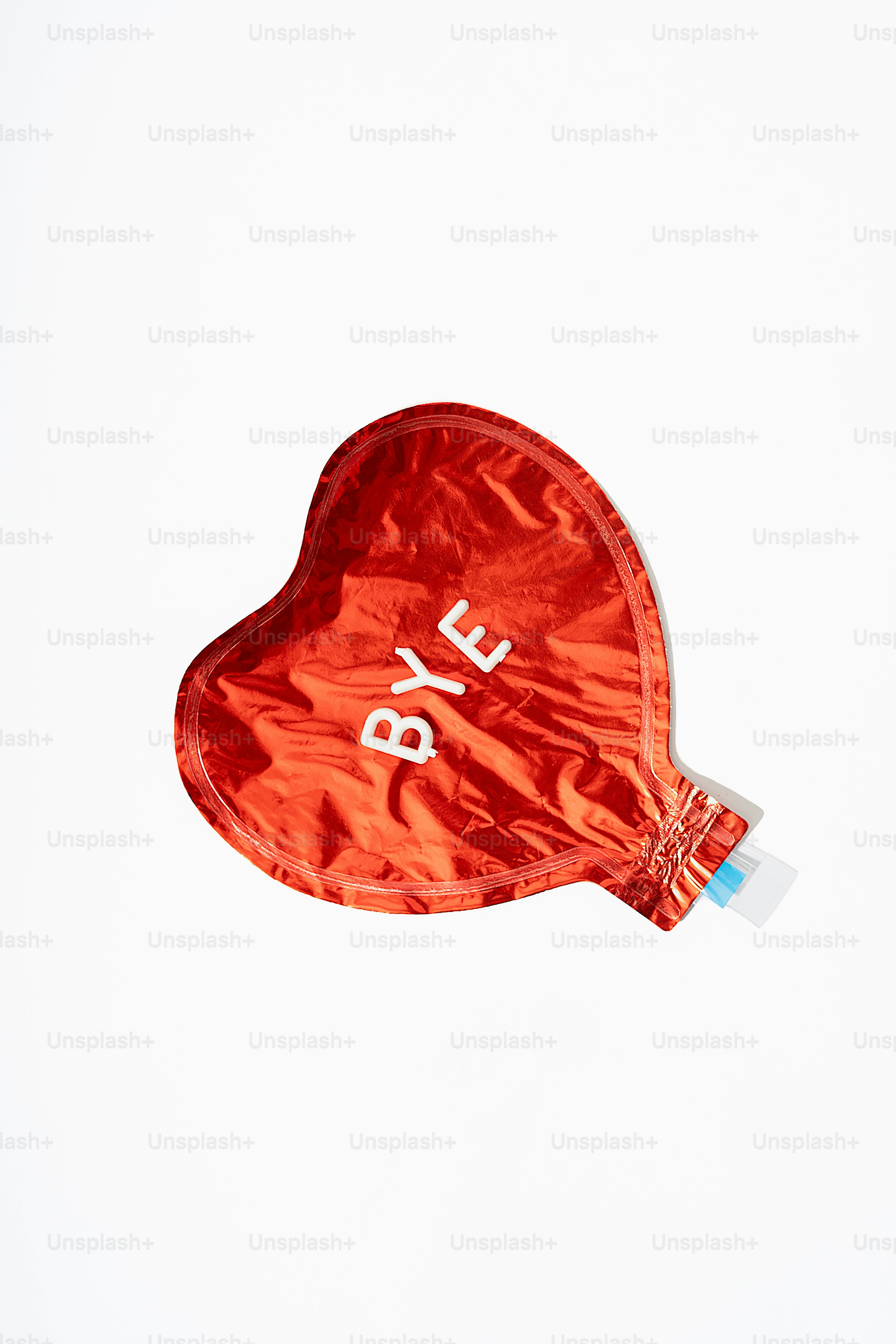 Balon berbentuk hati merah dengan tulisan "bye" di atasnya.