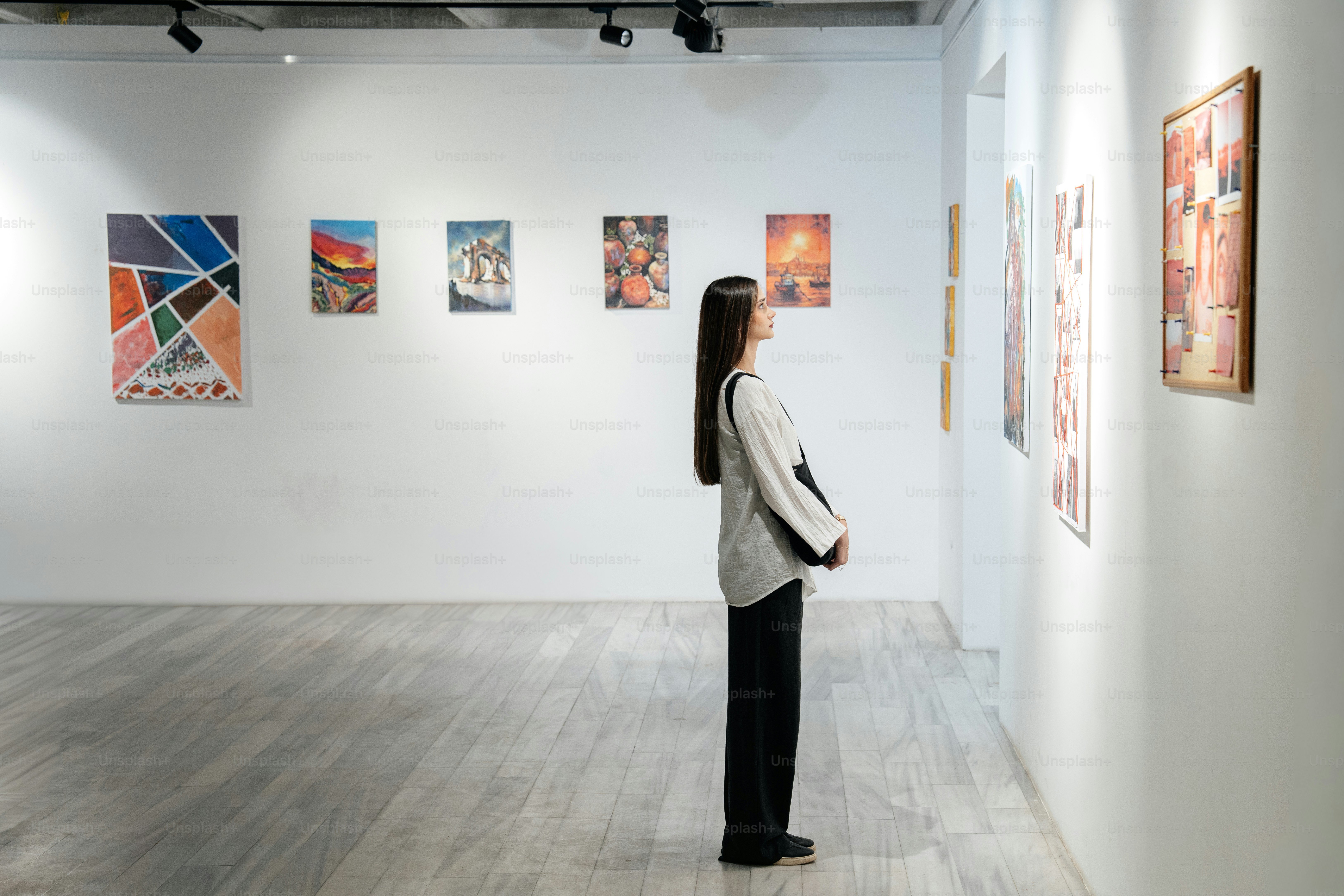 Woman observing artwork in a modern gallery
