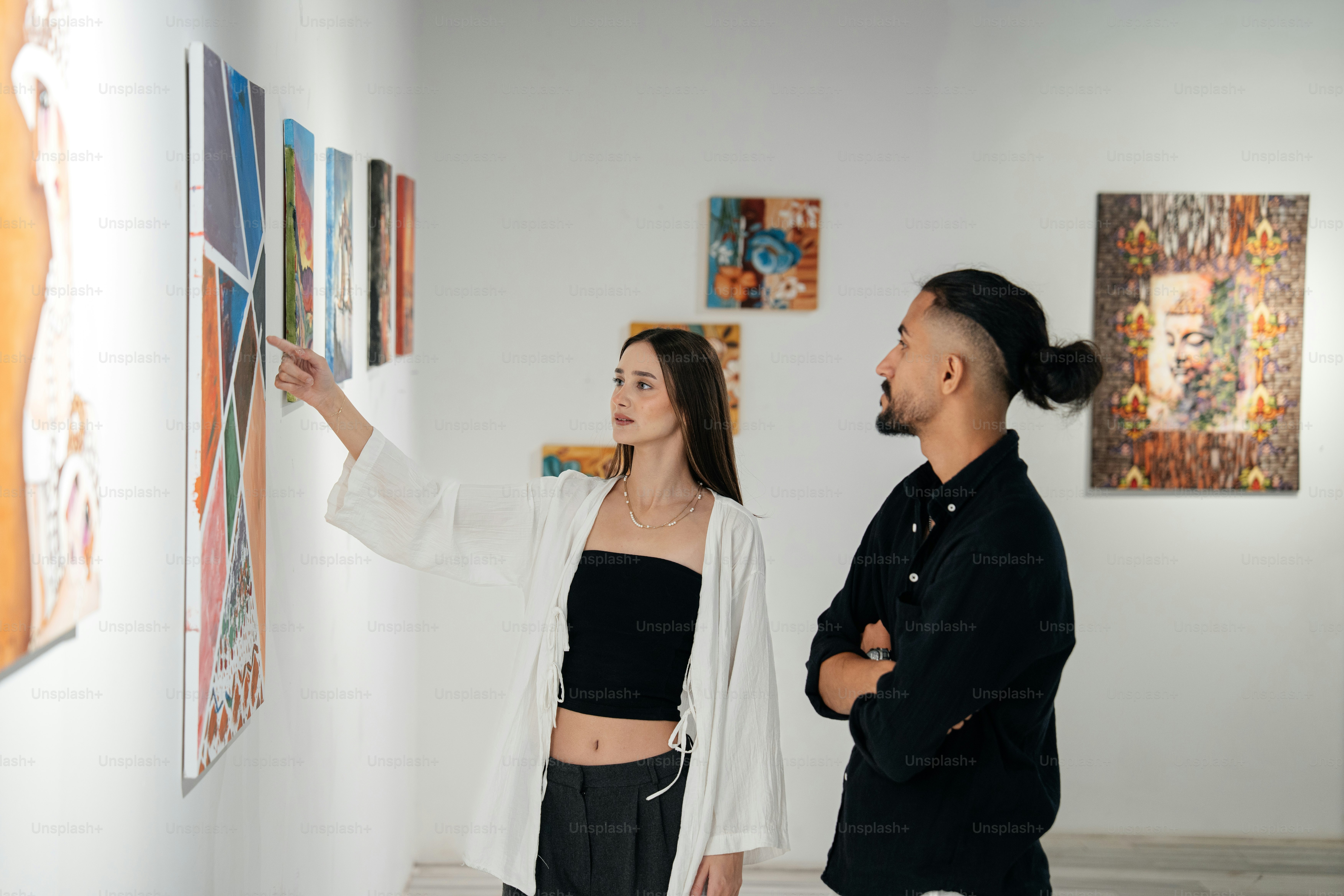 Two people observing artwork in a modern gallery. photo – Art Image on ...
