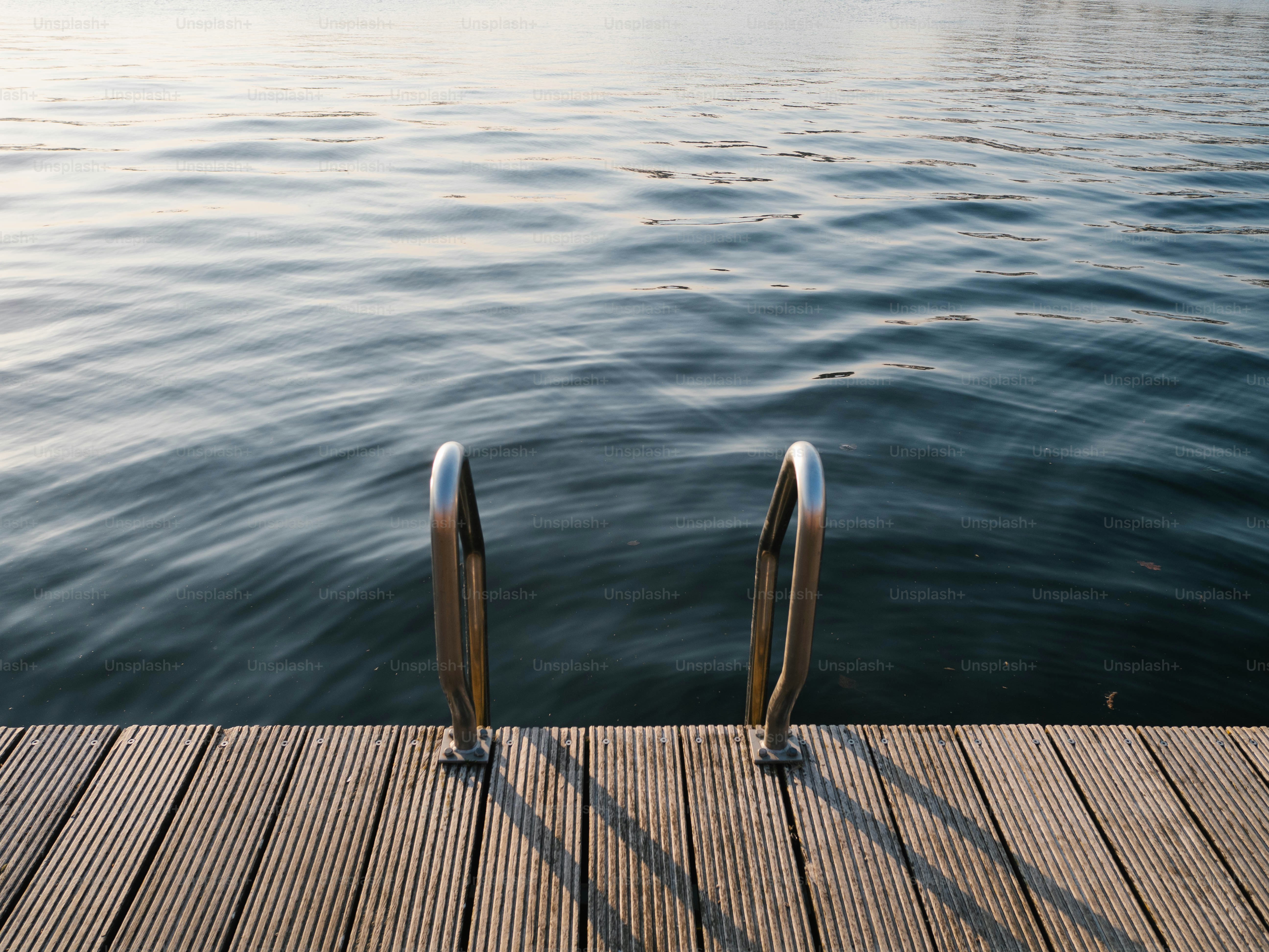 Wooden dock with metal ladder leading into calm water