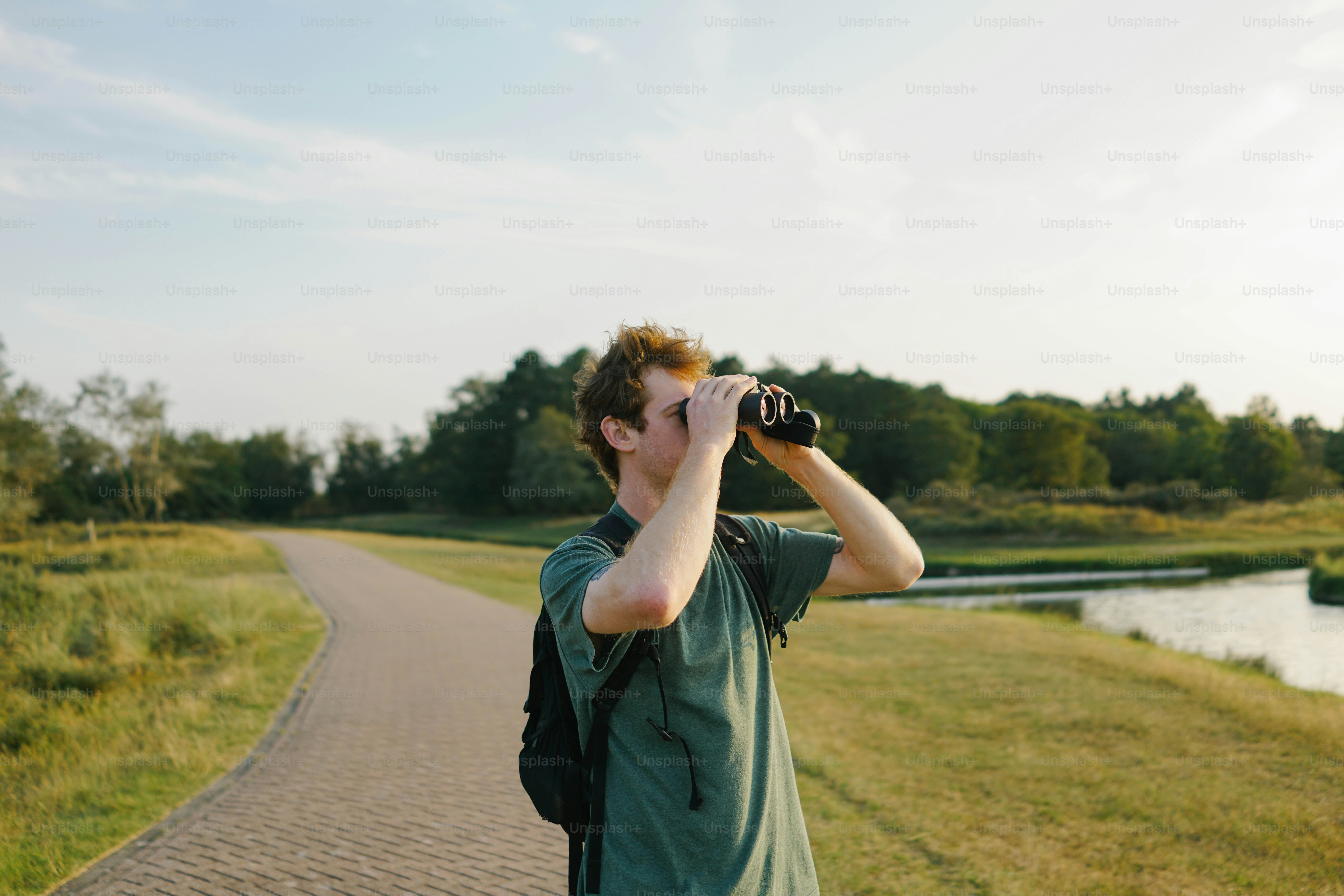 Young man looking through binoculars in nature