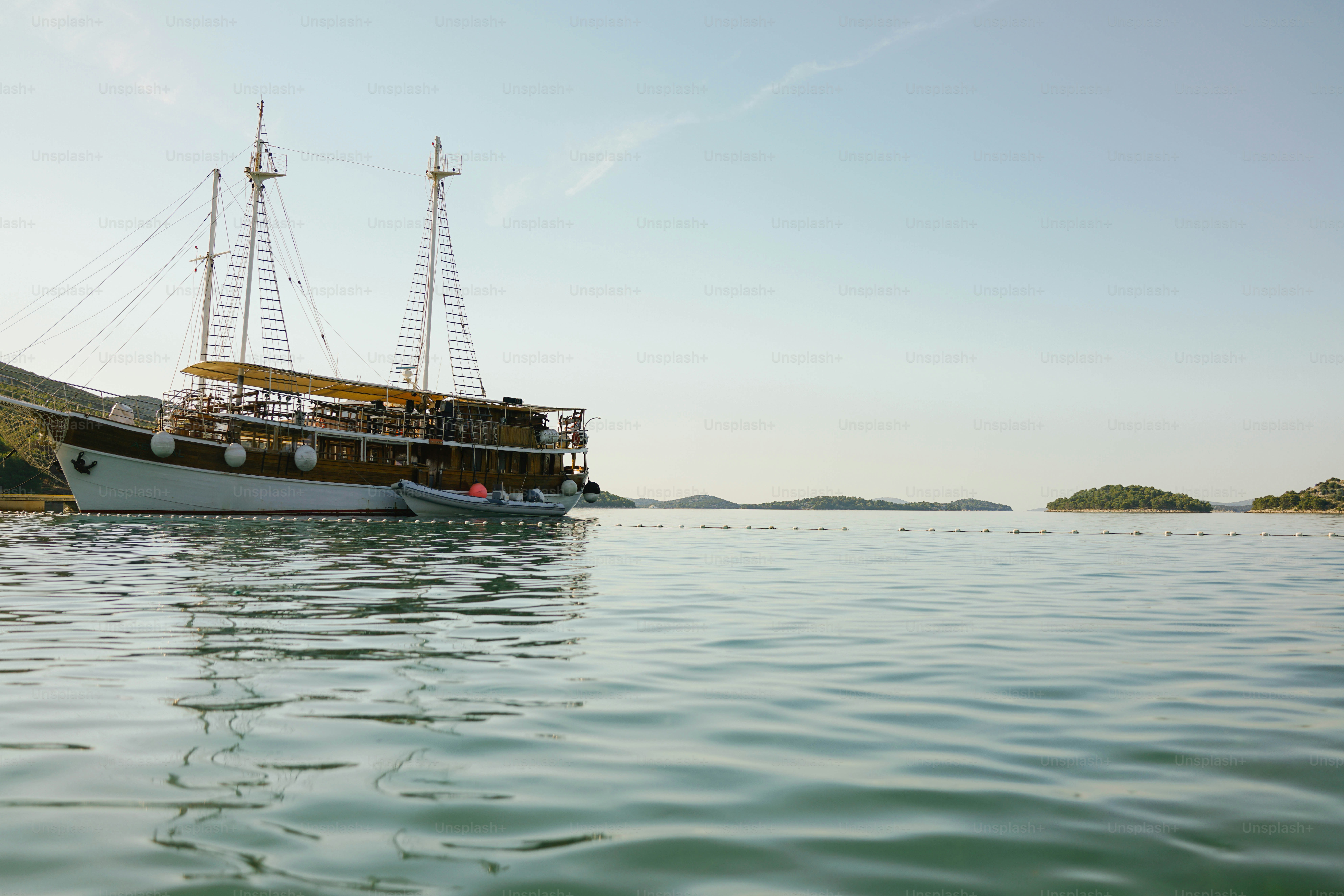 Large wooden boat anchored in calm blue water