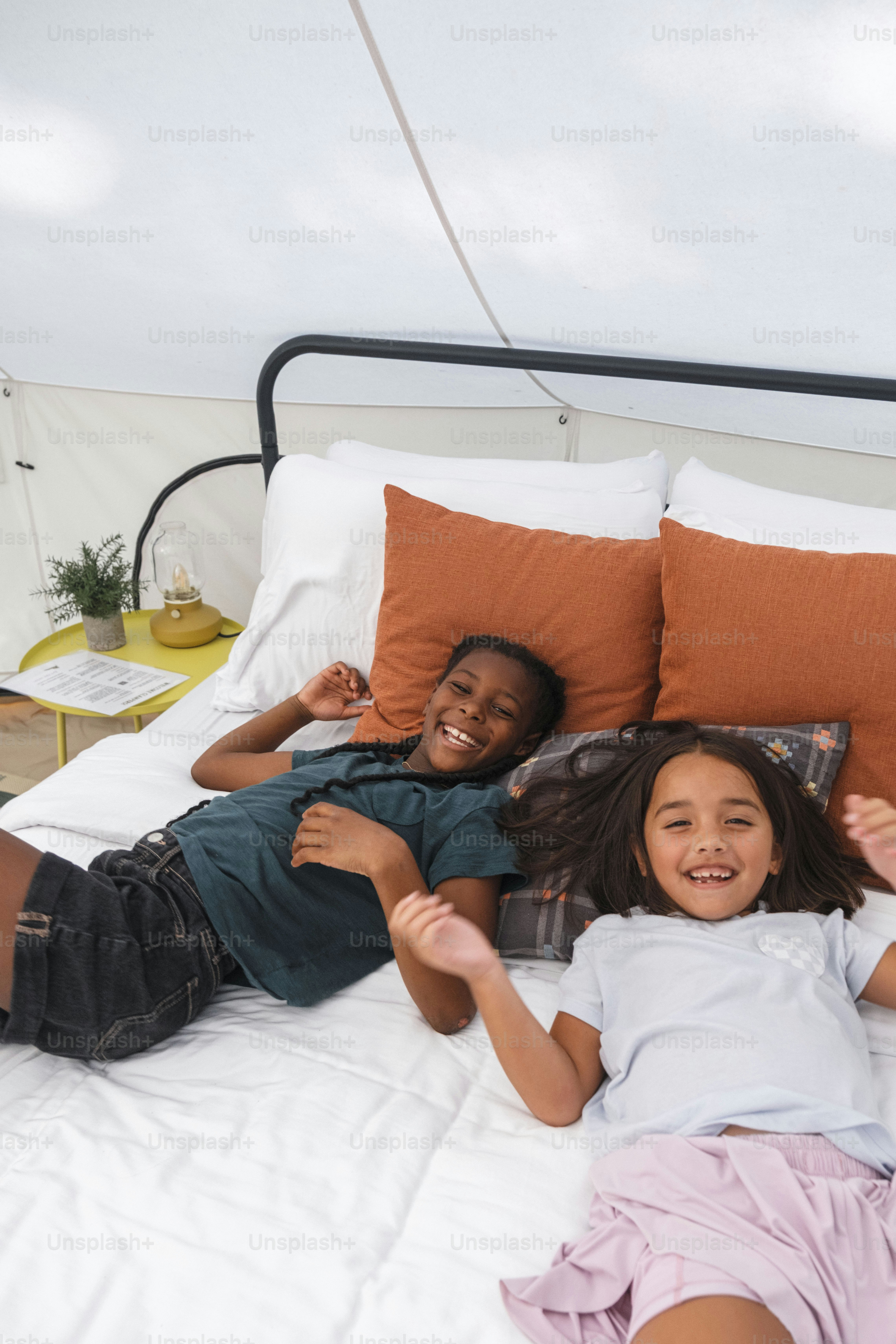 Two happy children lying on a bed