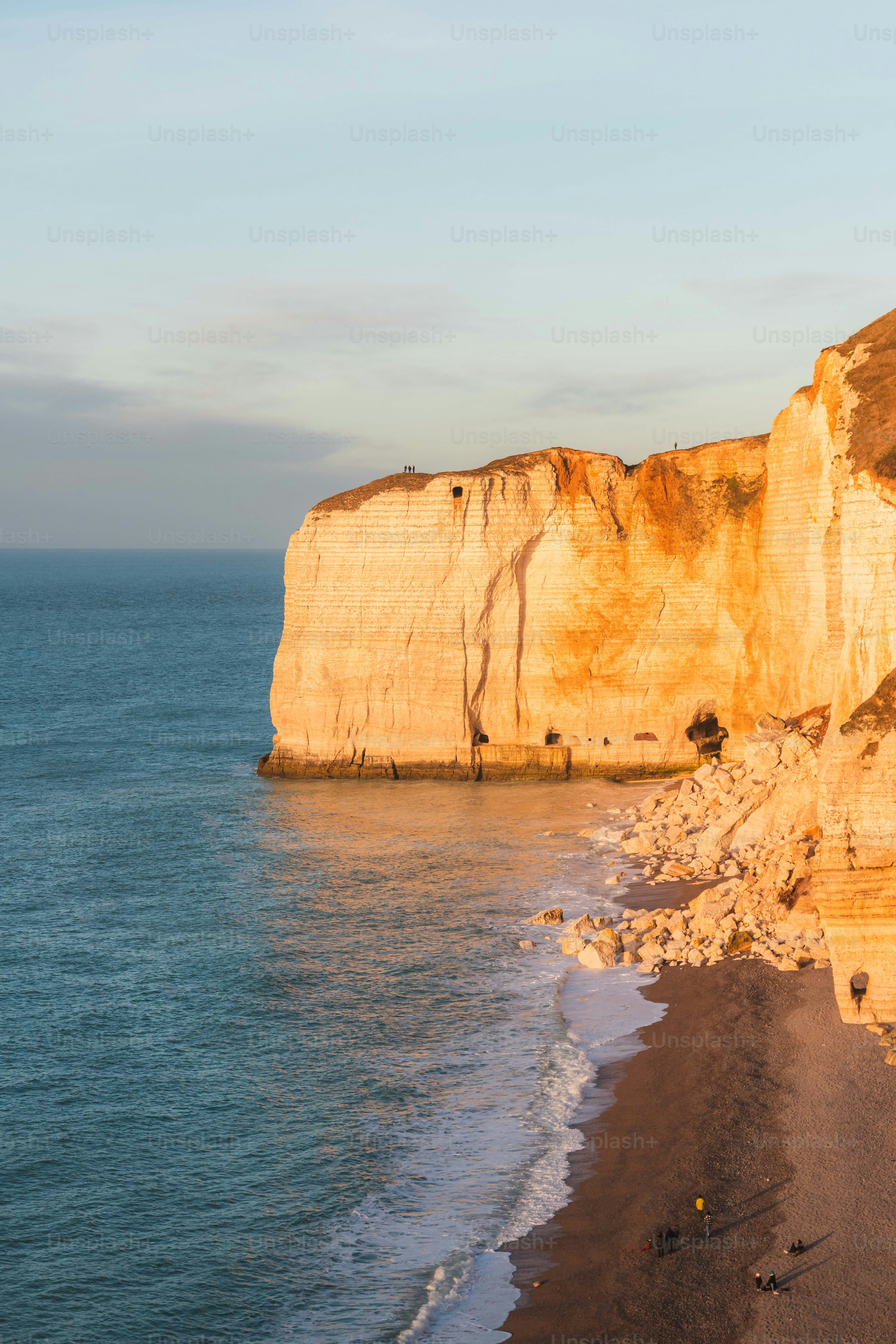 Sunlit cliffs and ocean shoreline with gentle waves