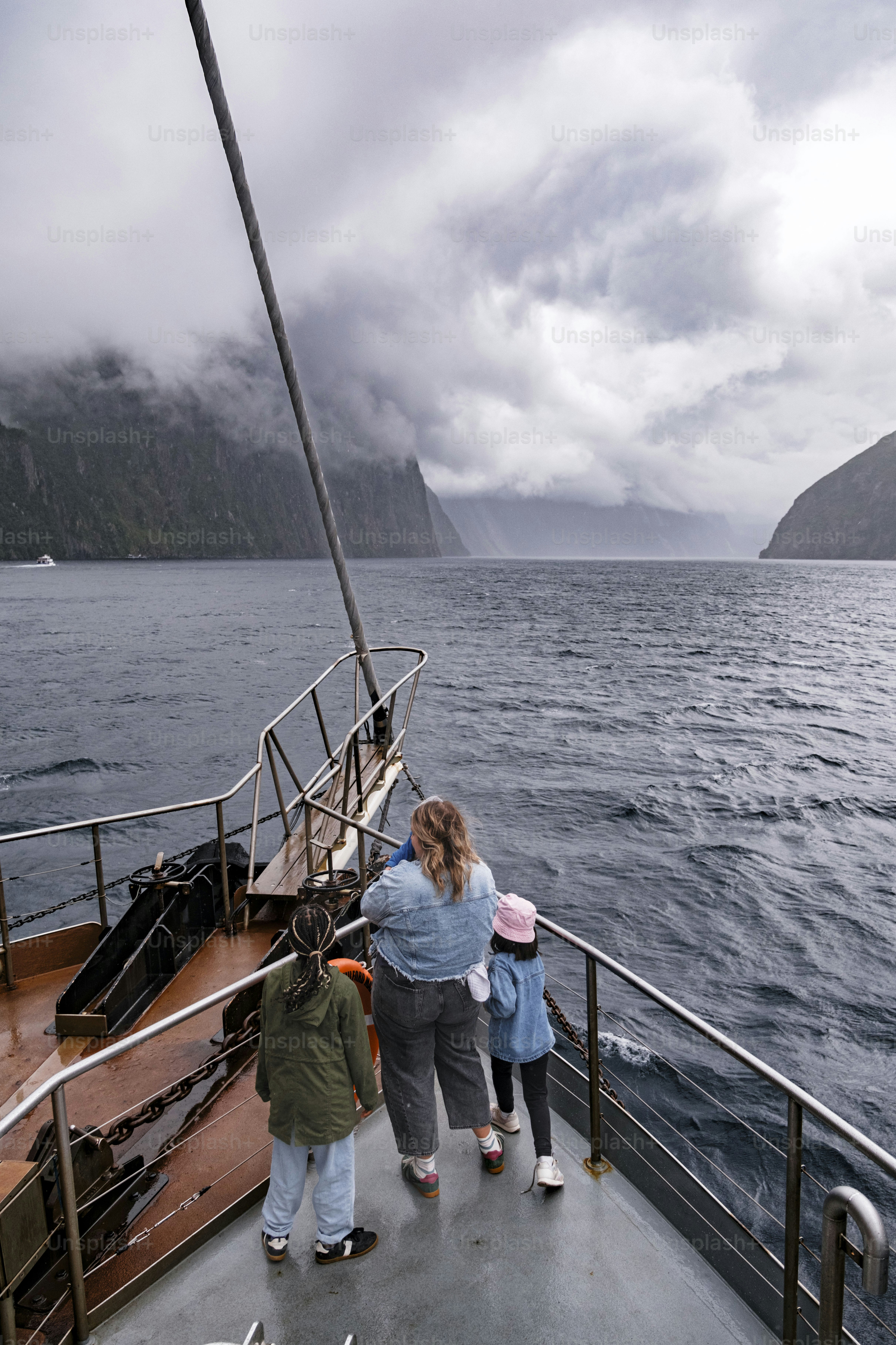 Gente en un bote mirando montañas brumosas