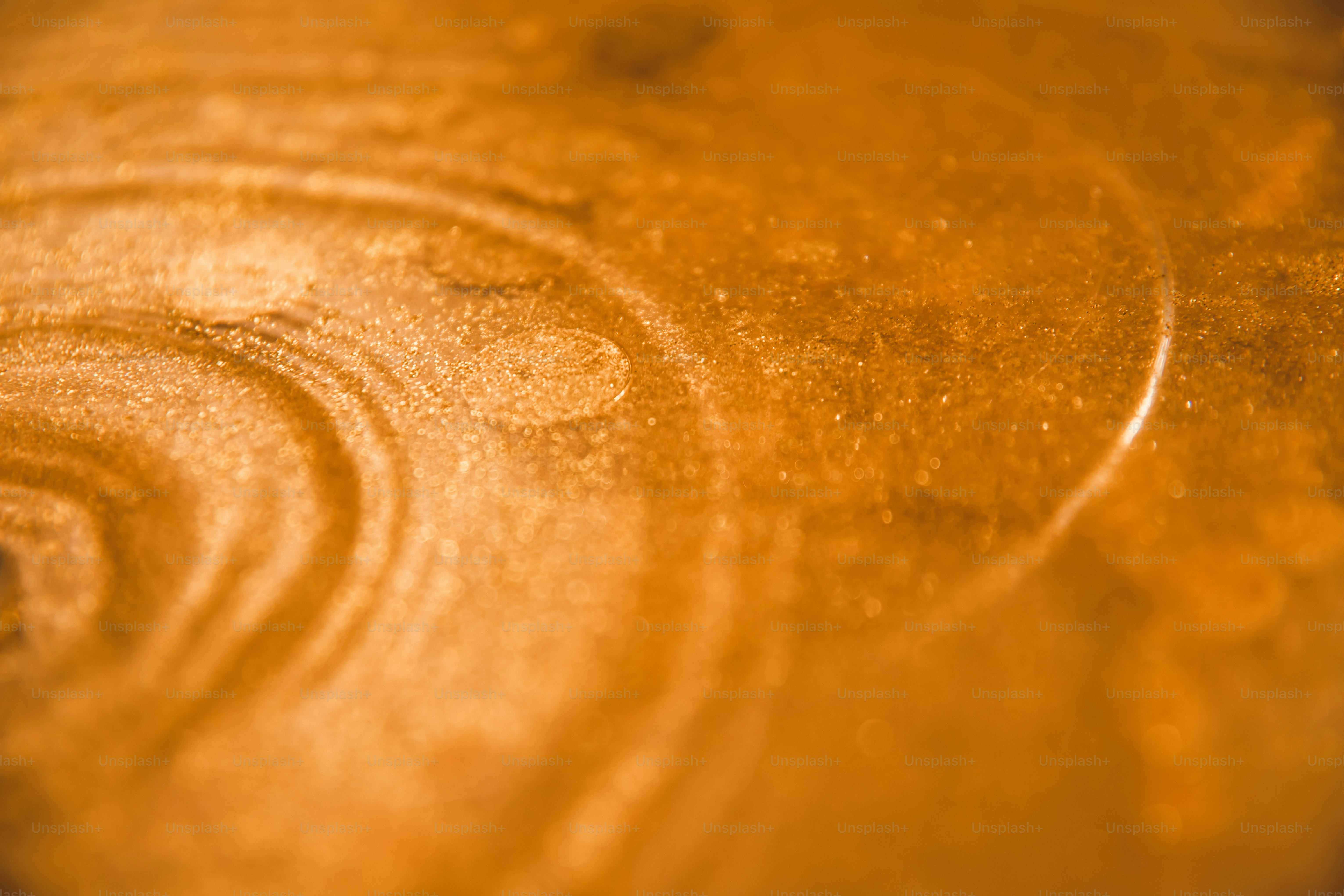 Abstraktes wirbelndes Muster mit orangefarbenen und goldenen Farben