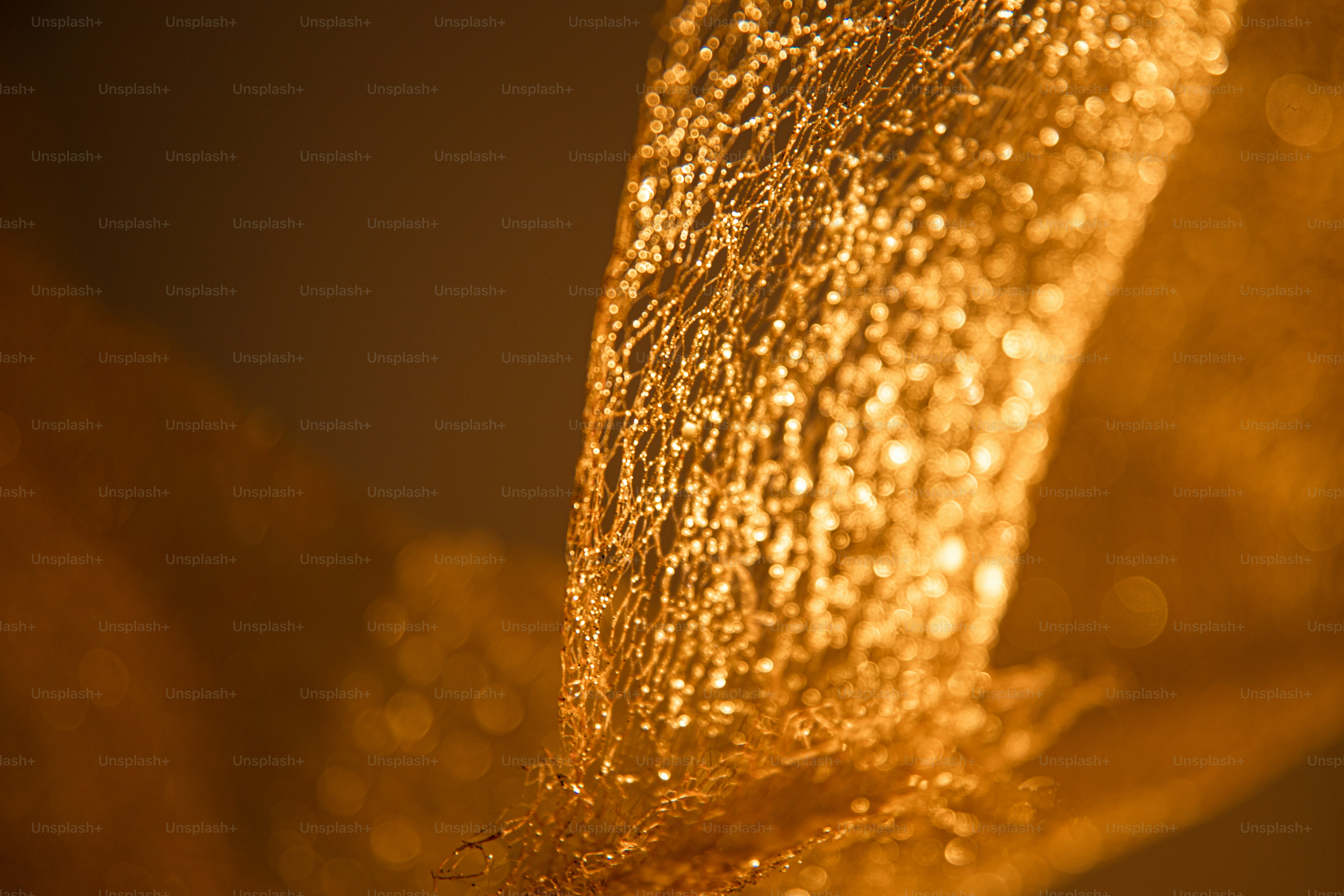 Nahaufnahme aus strukturiertem goldenem Stoff mit funkelnden Highlights