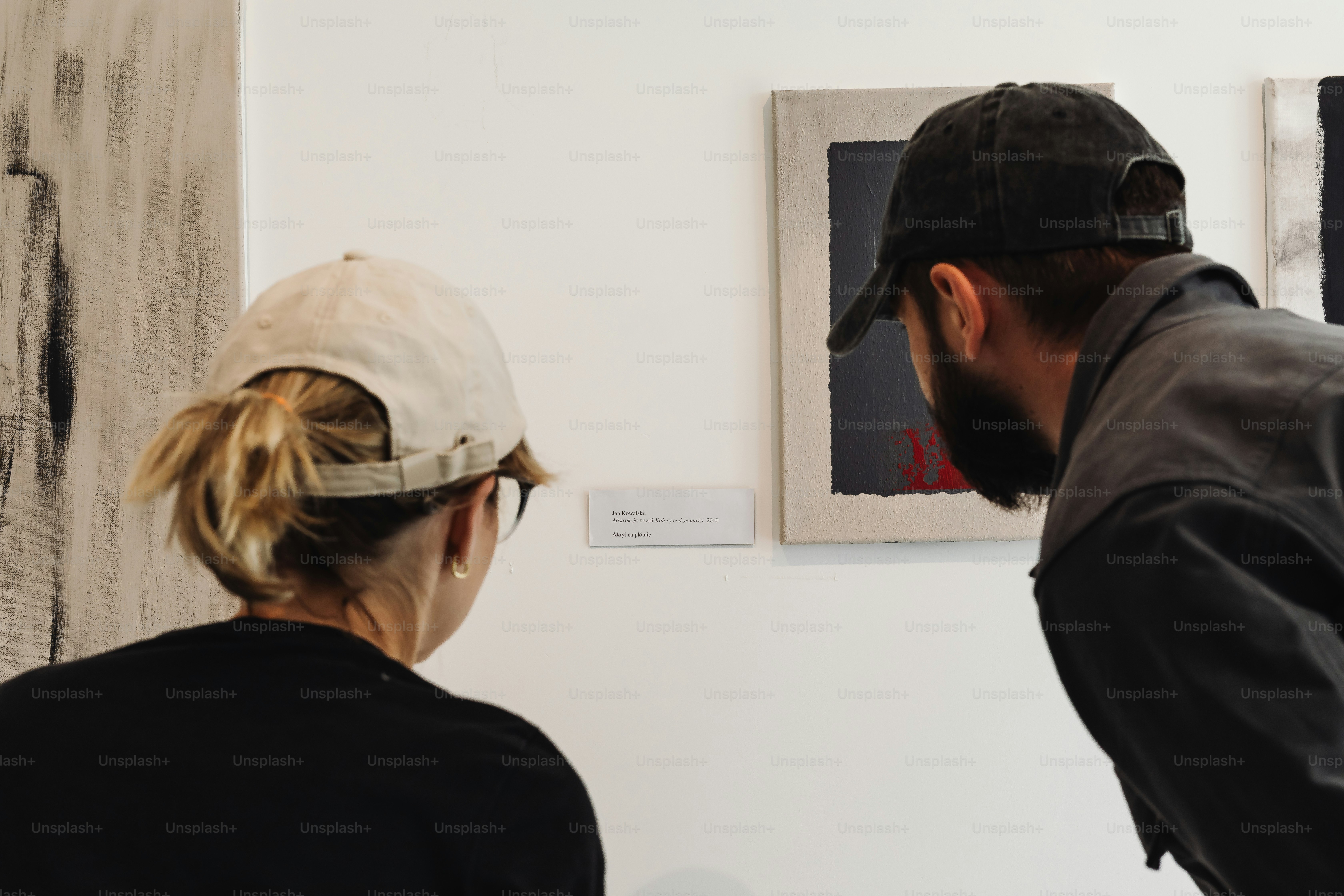 Two people looking at artwork in a gallery.