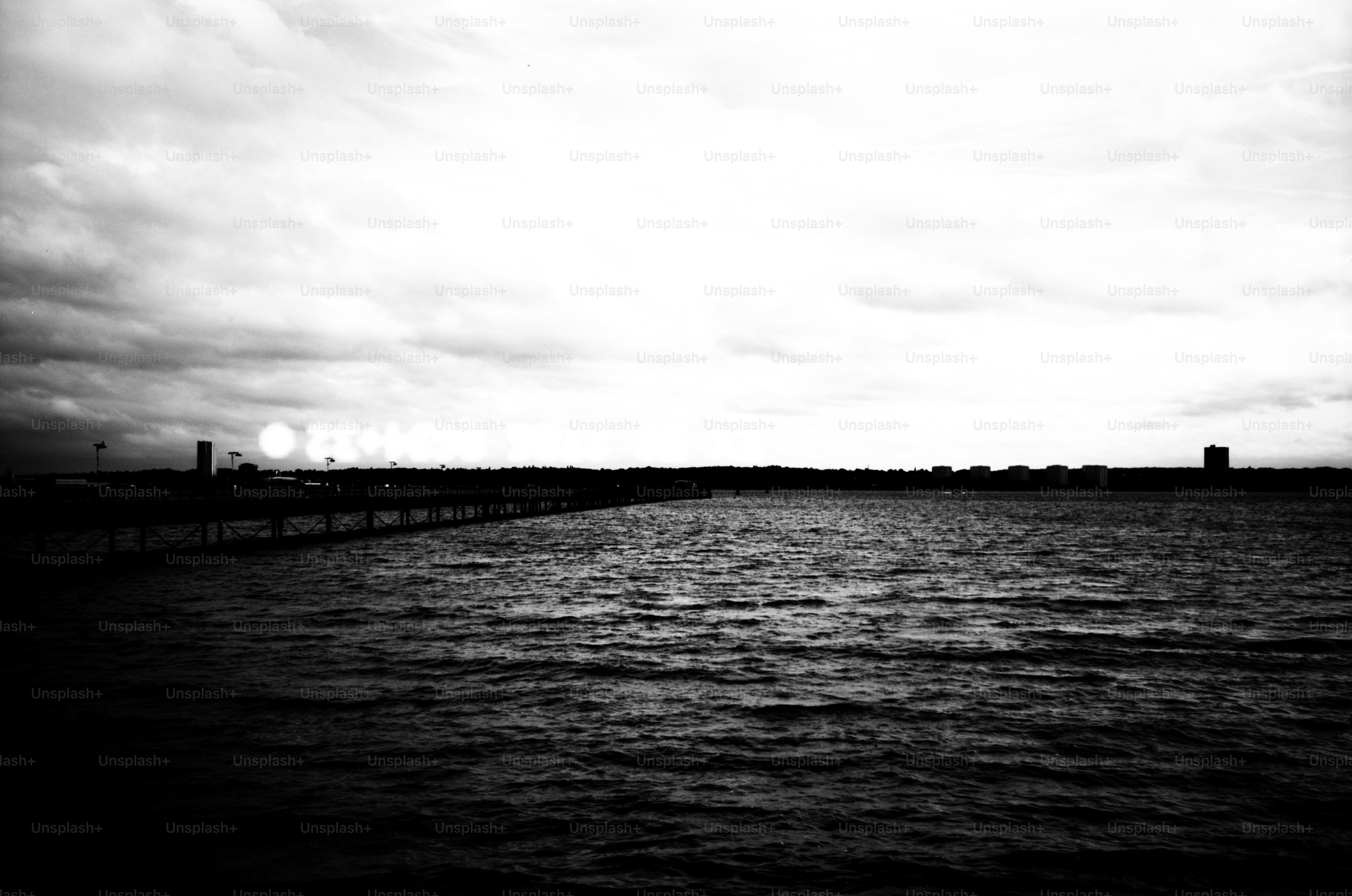 Dark, moody seascape with distant city skyline.