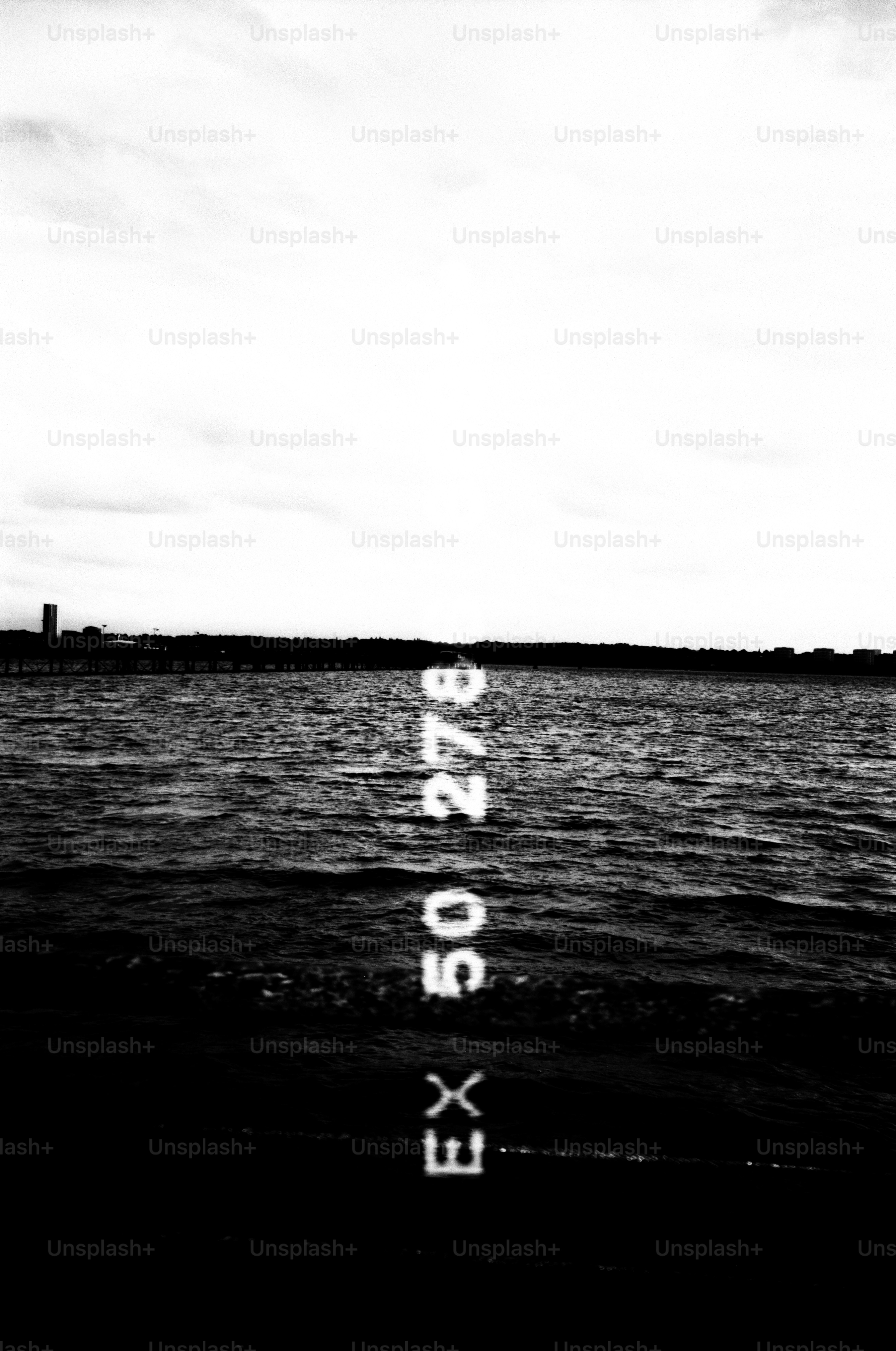 Black and white of a body of water with text.