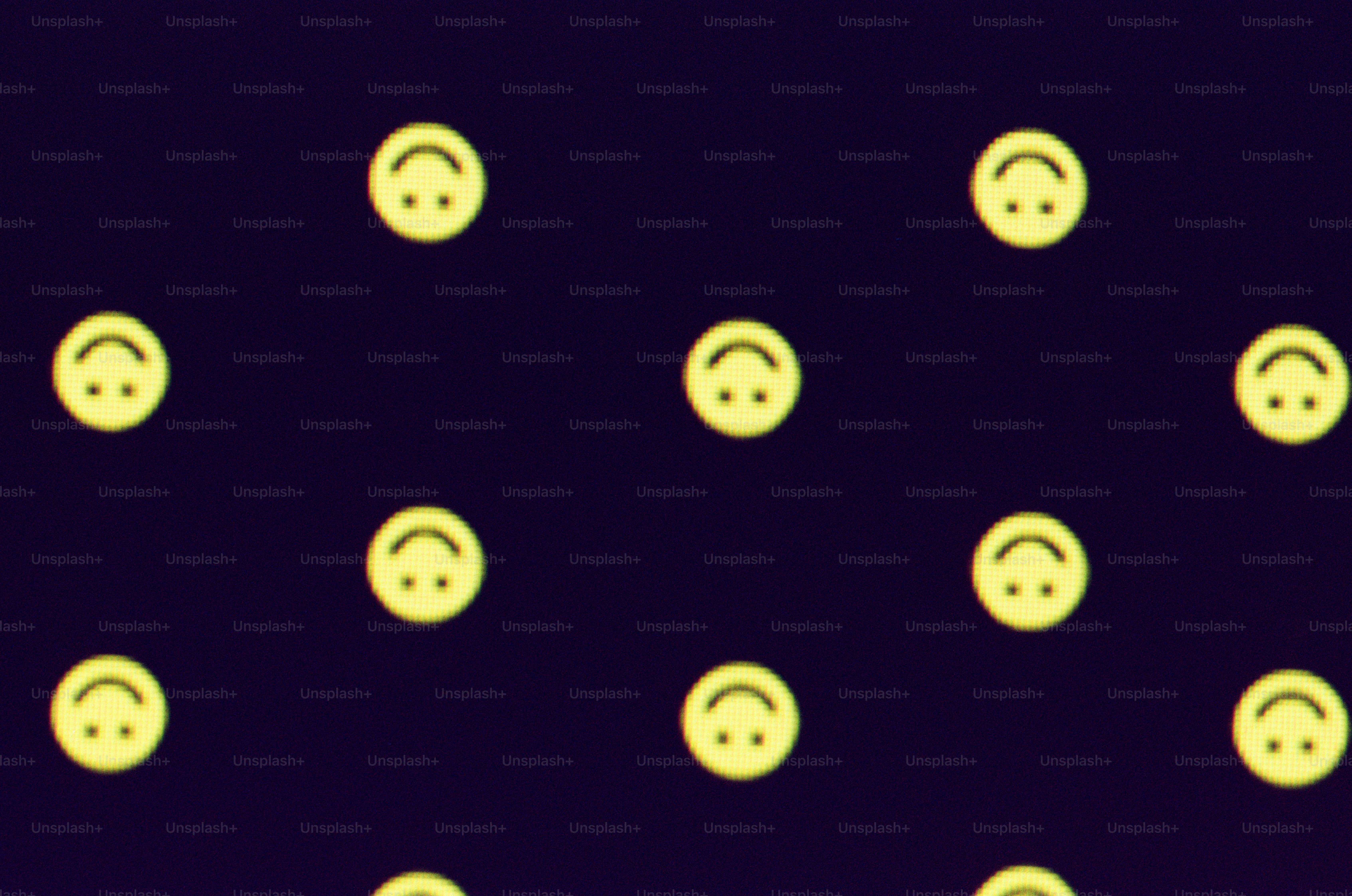 暗い背景に黄色のスマイリーフェイスがたくさんある
