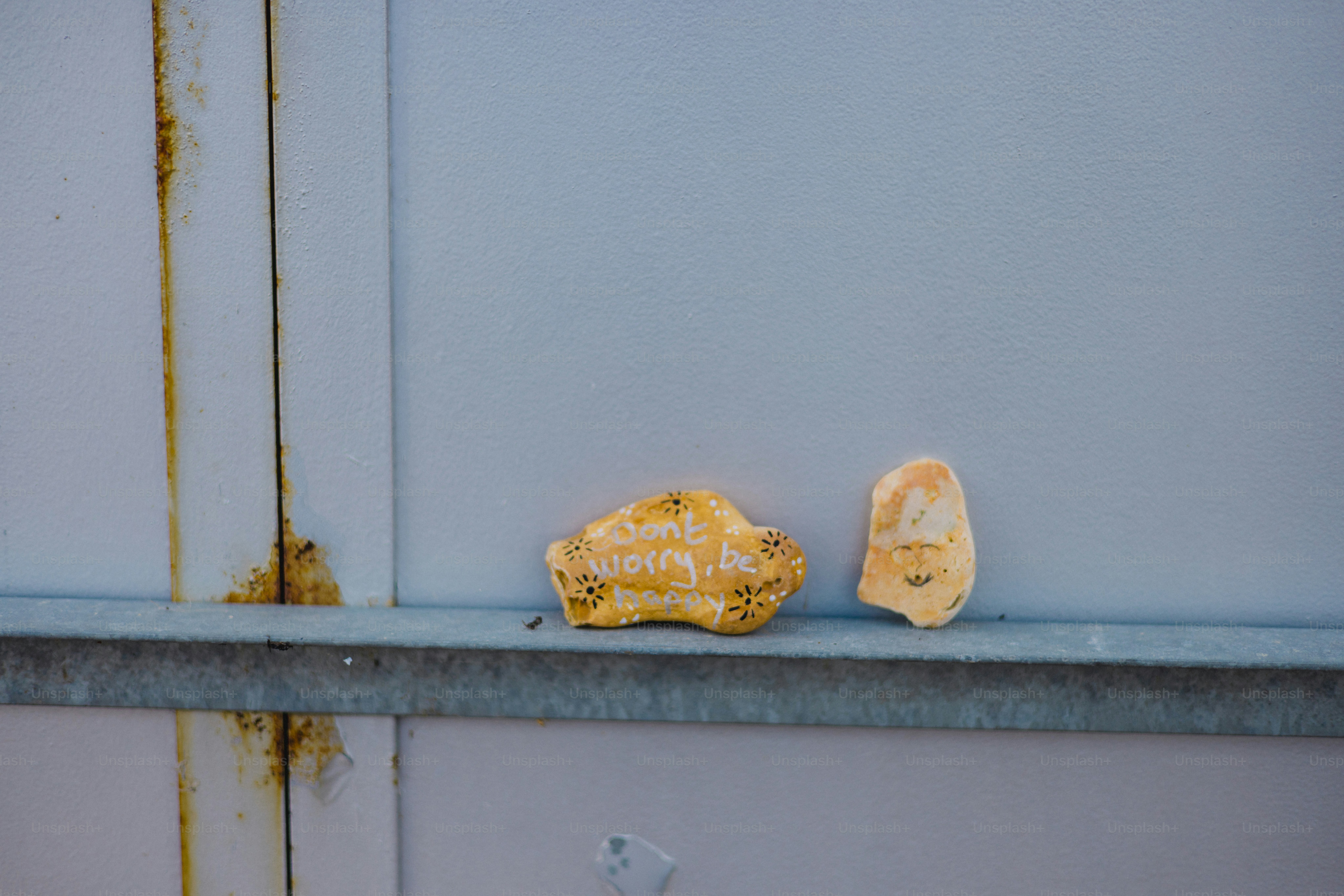 Two rocks resting on a metal shelf.