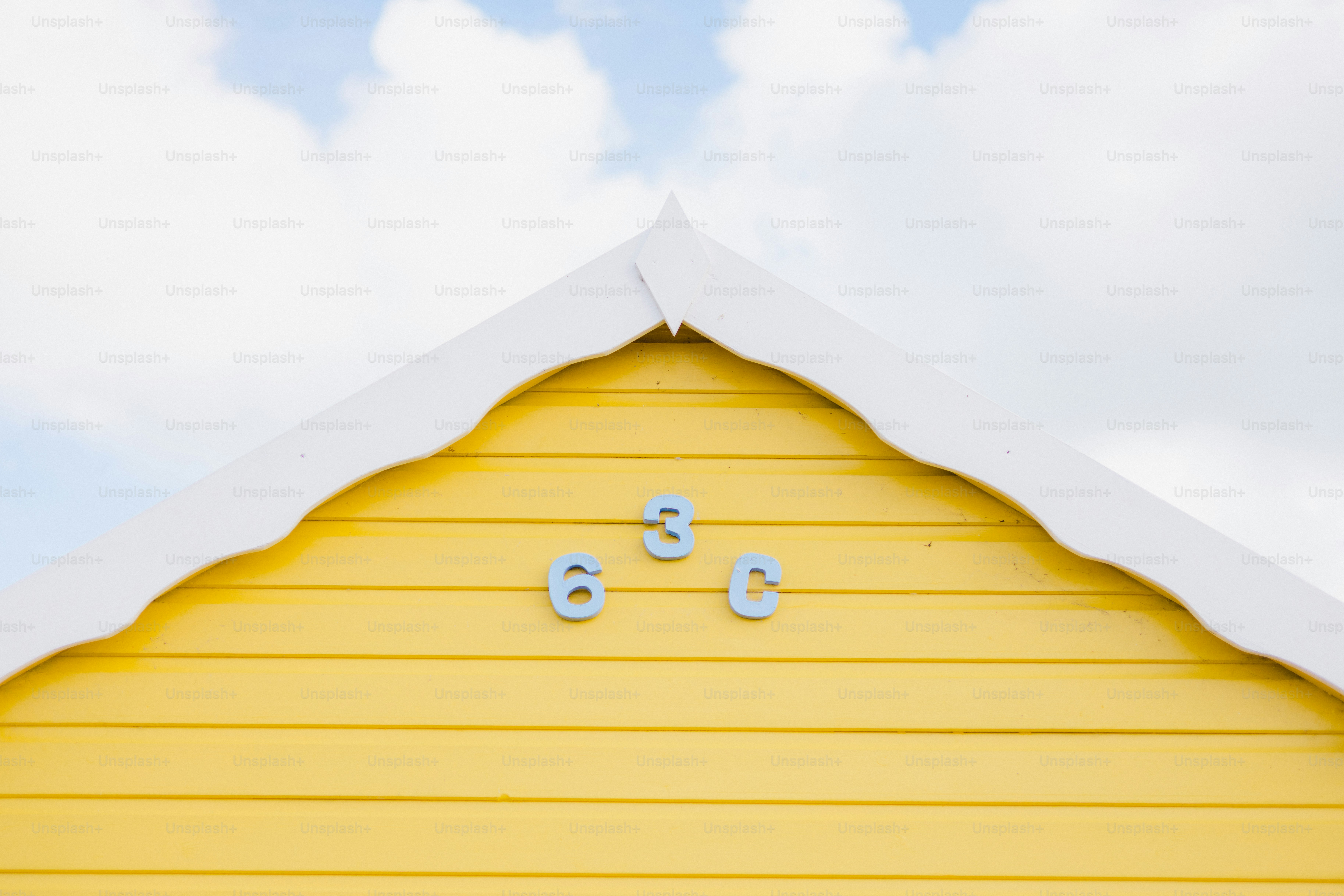Gelbe Strandhütte mit der Nummer 638 unter bewölktem Himmel