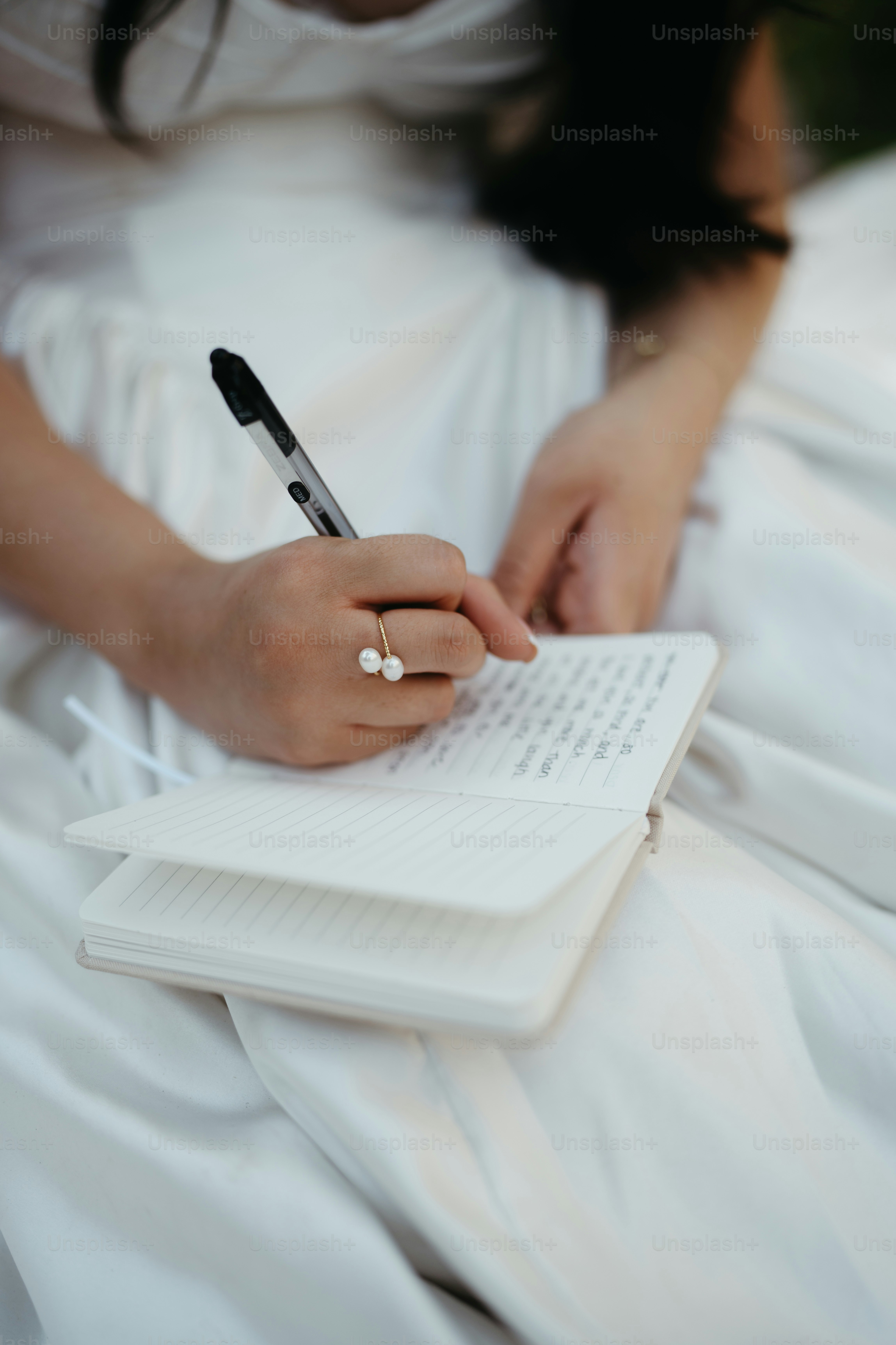 Woman writing in a small notebook with a pen