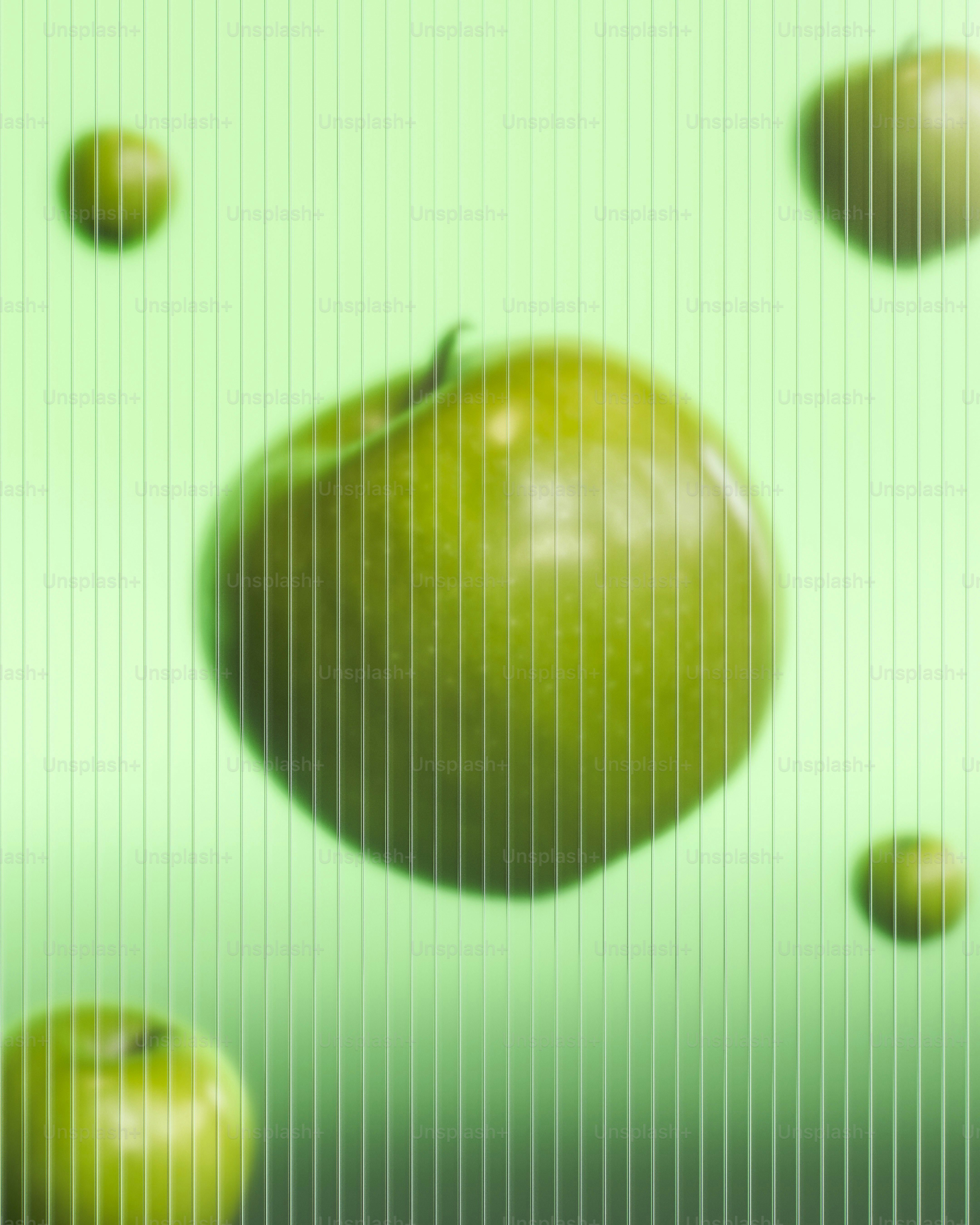 Green apples floating on a striped green background