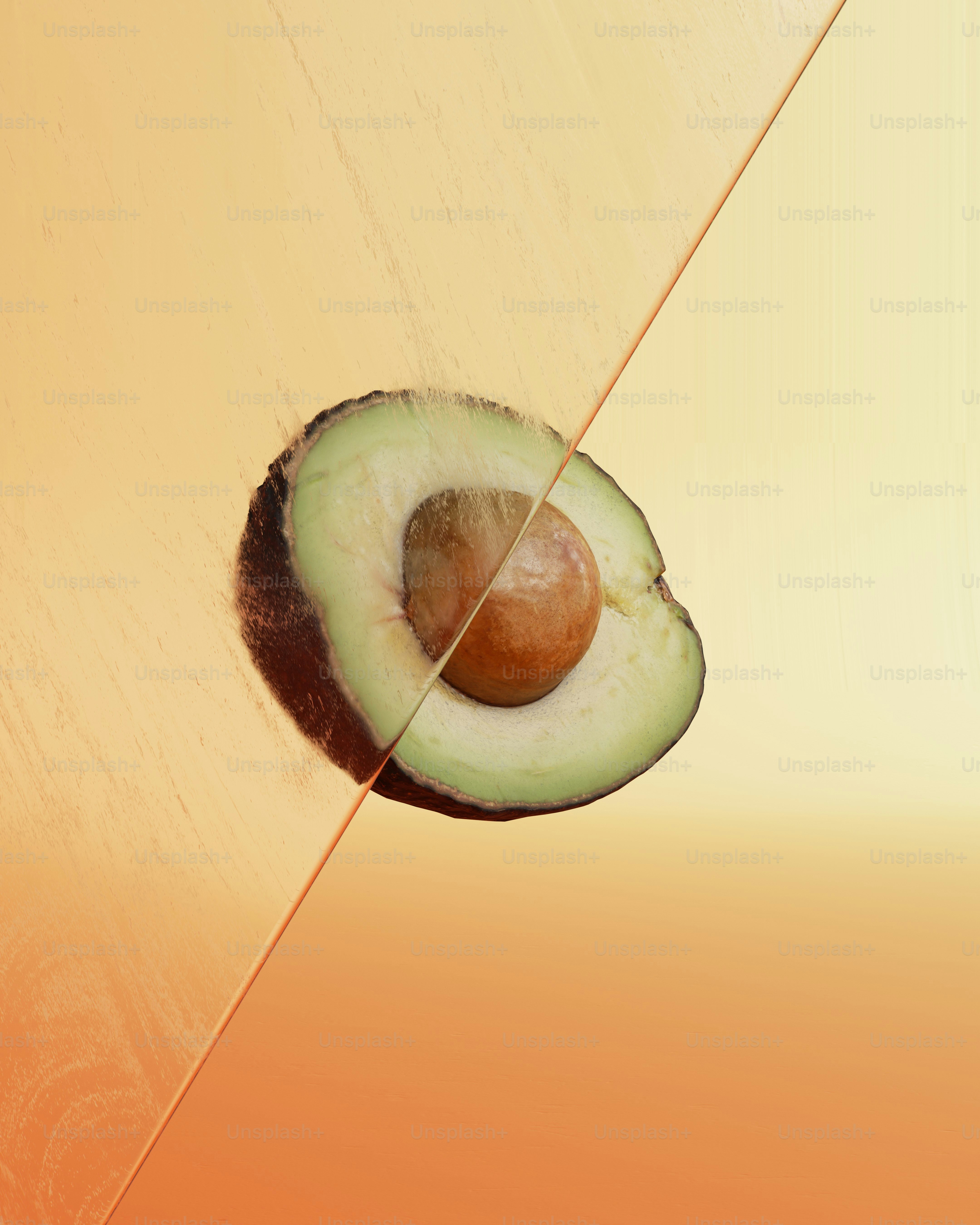 Medio aguacate con hueso sobre fondo naranja