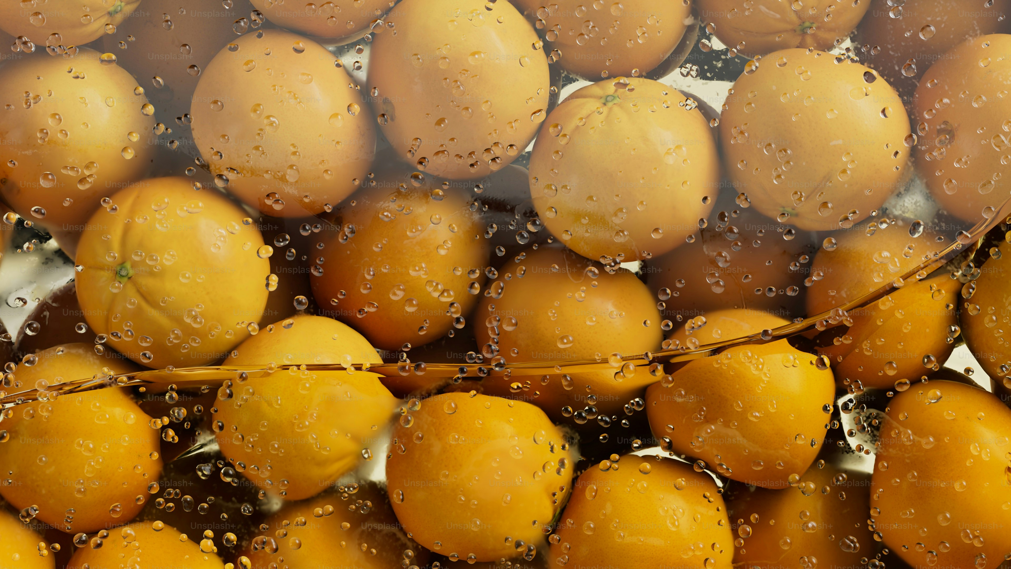 Oranges submerged in bubbly water with a branch.