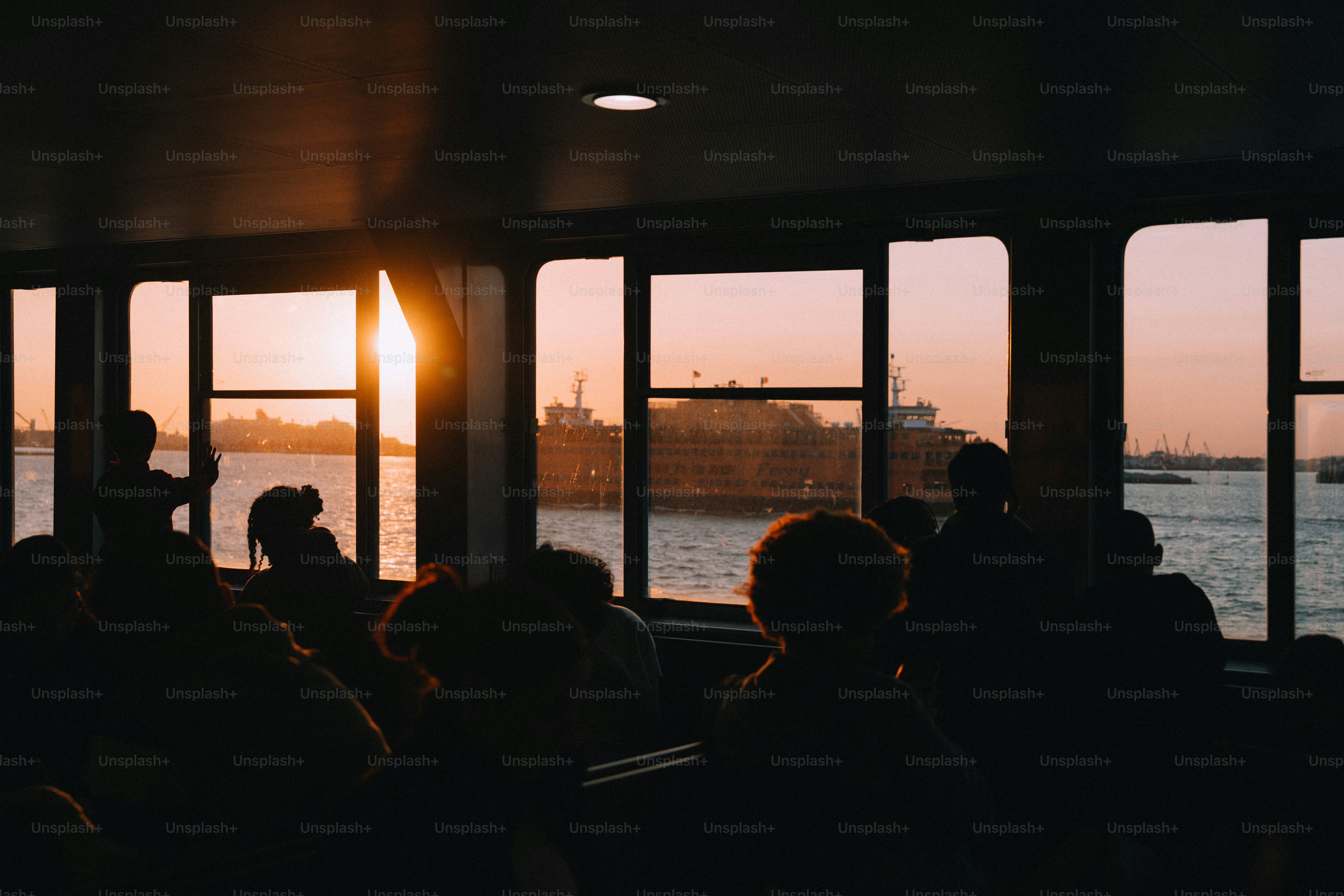People silhouetted on a ferry at sunset