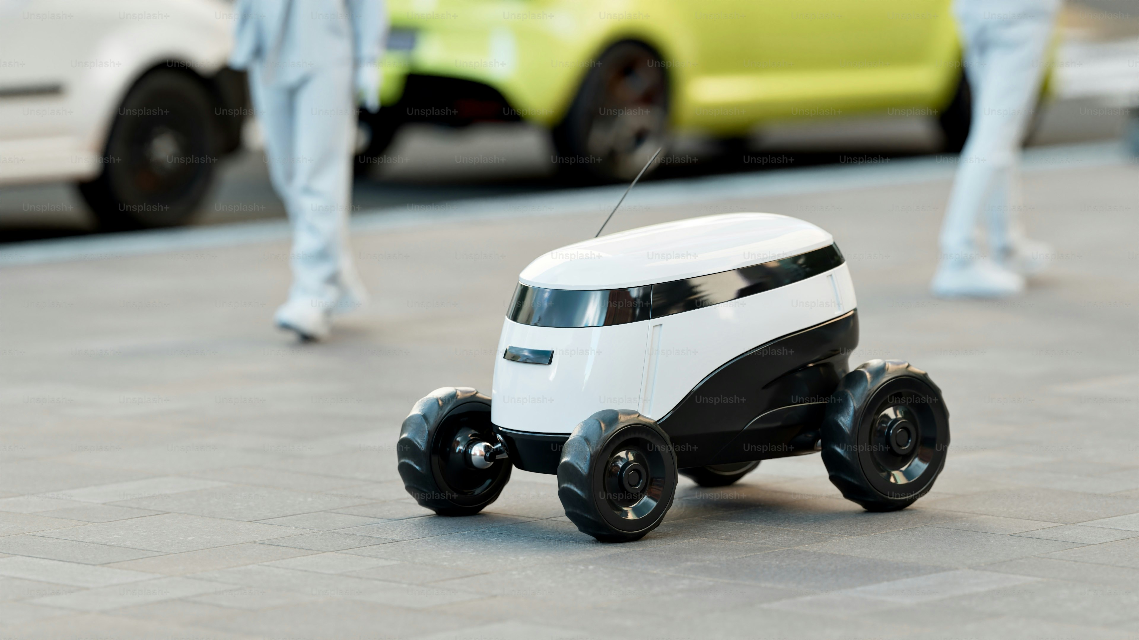 A white delivery robot with black accents on wheels.