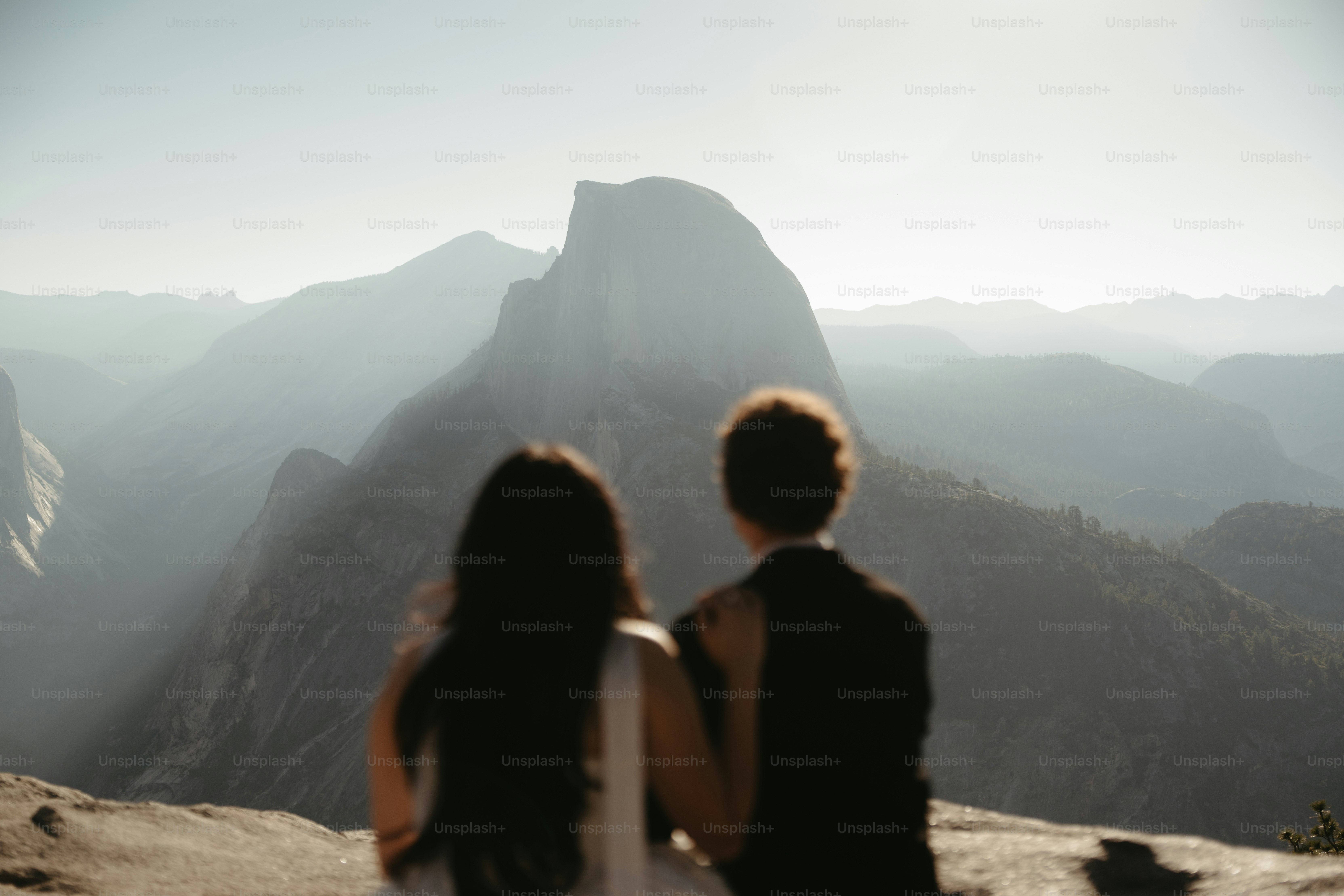 Couple admires majestic mountain landscape at sunrise