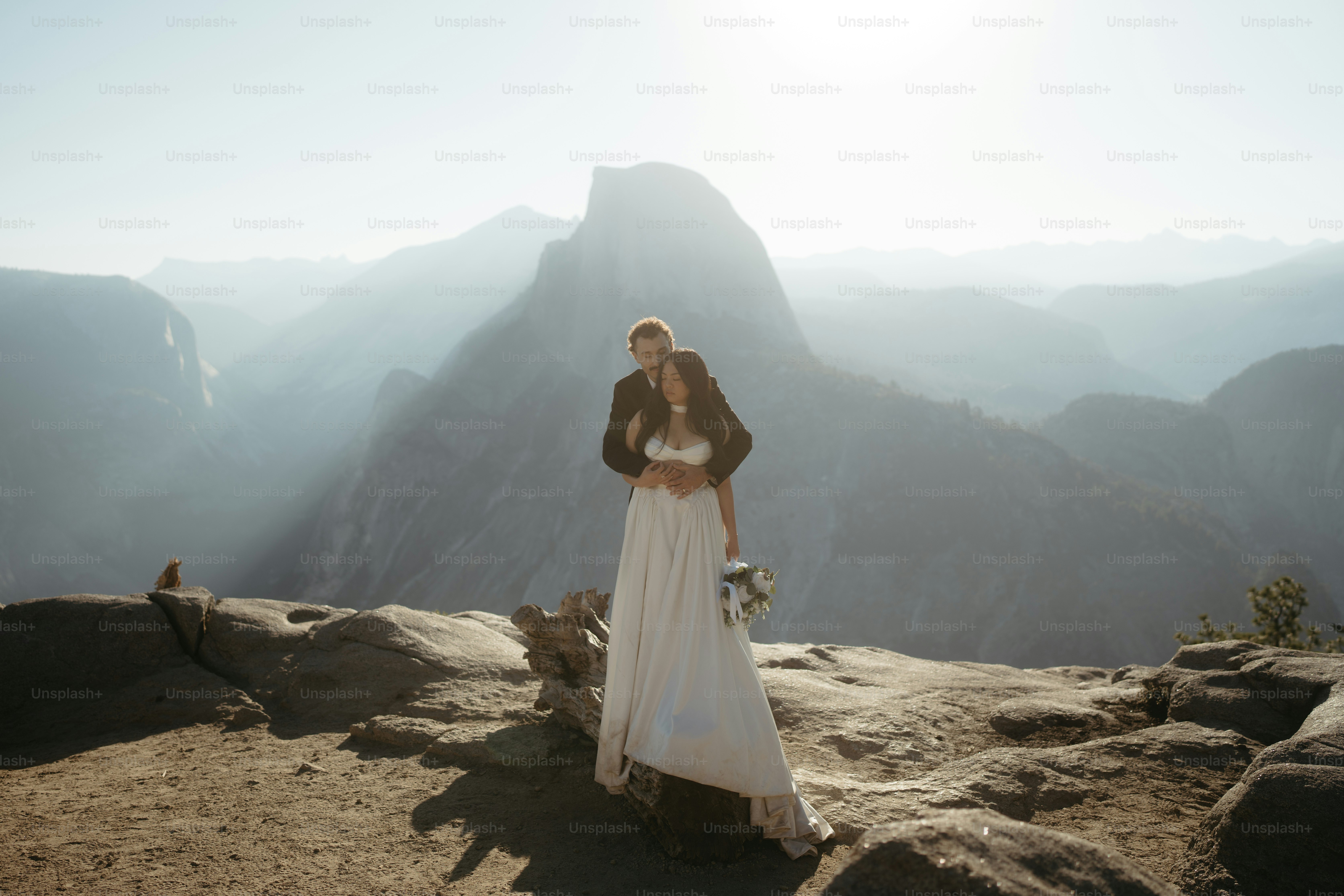 Couple embracing on a mountain overlook at sunrise