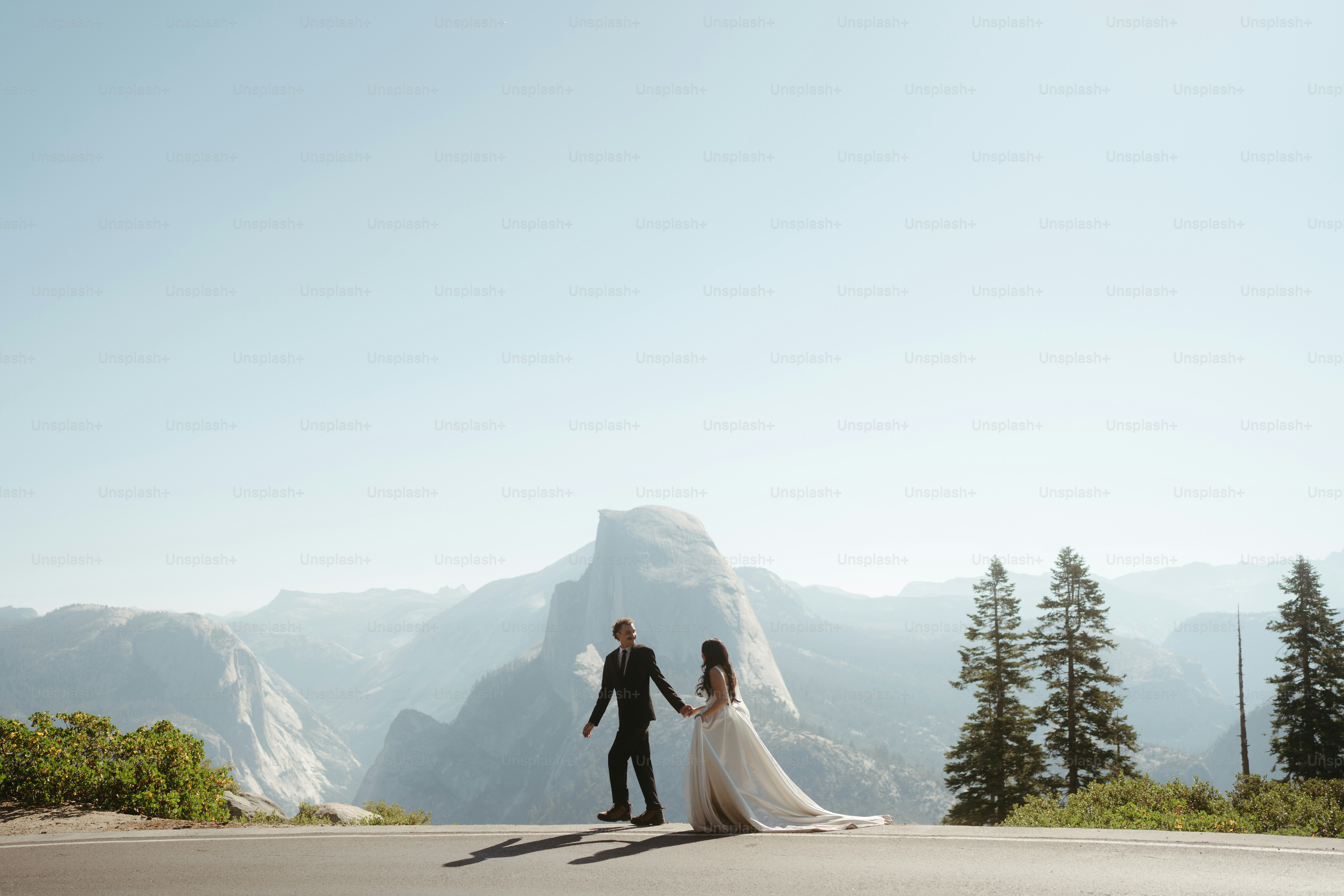 Couple holding hands with half dome in background