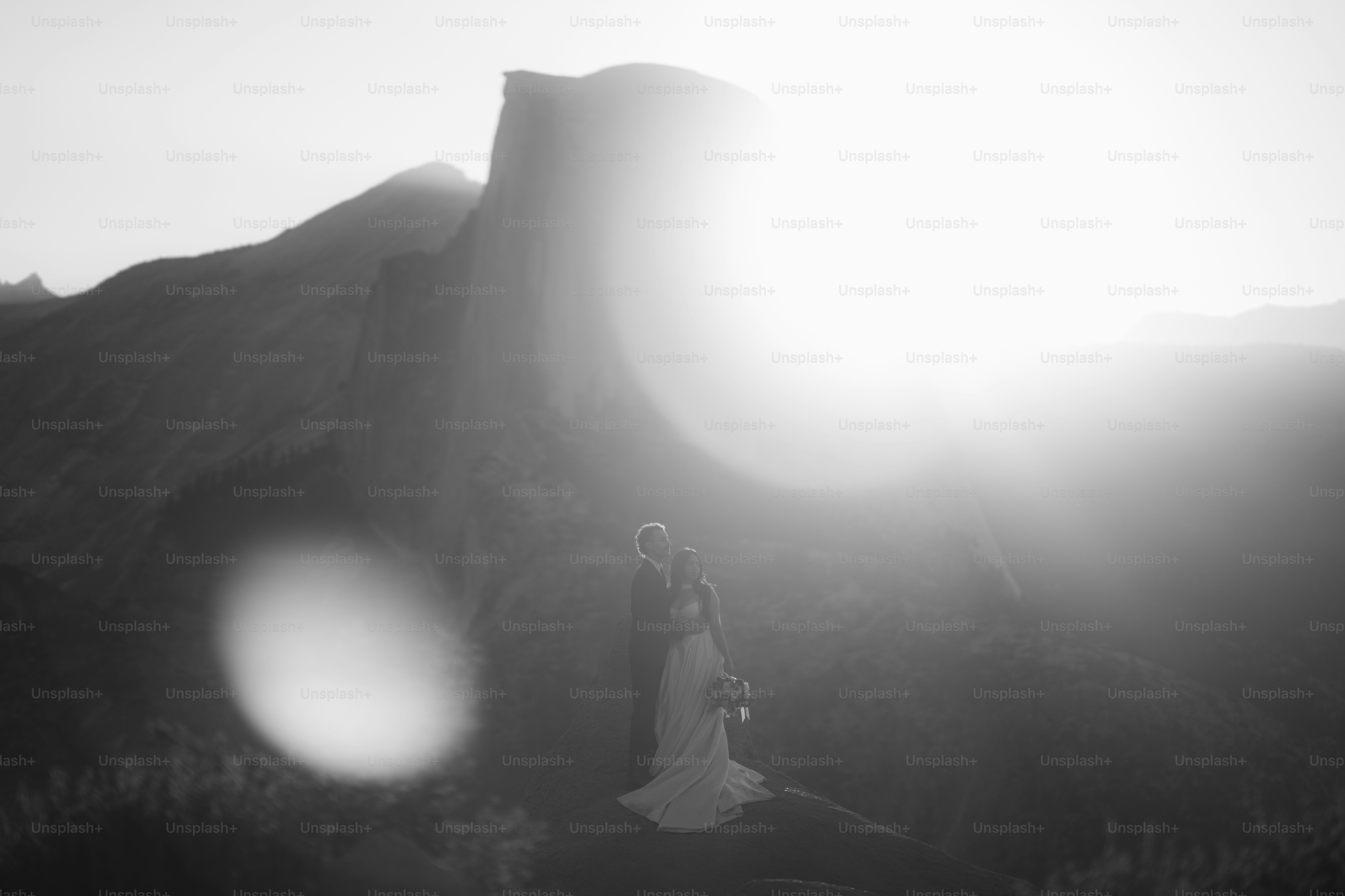 Bride and groom silhouetted against bright sun